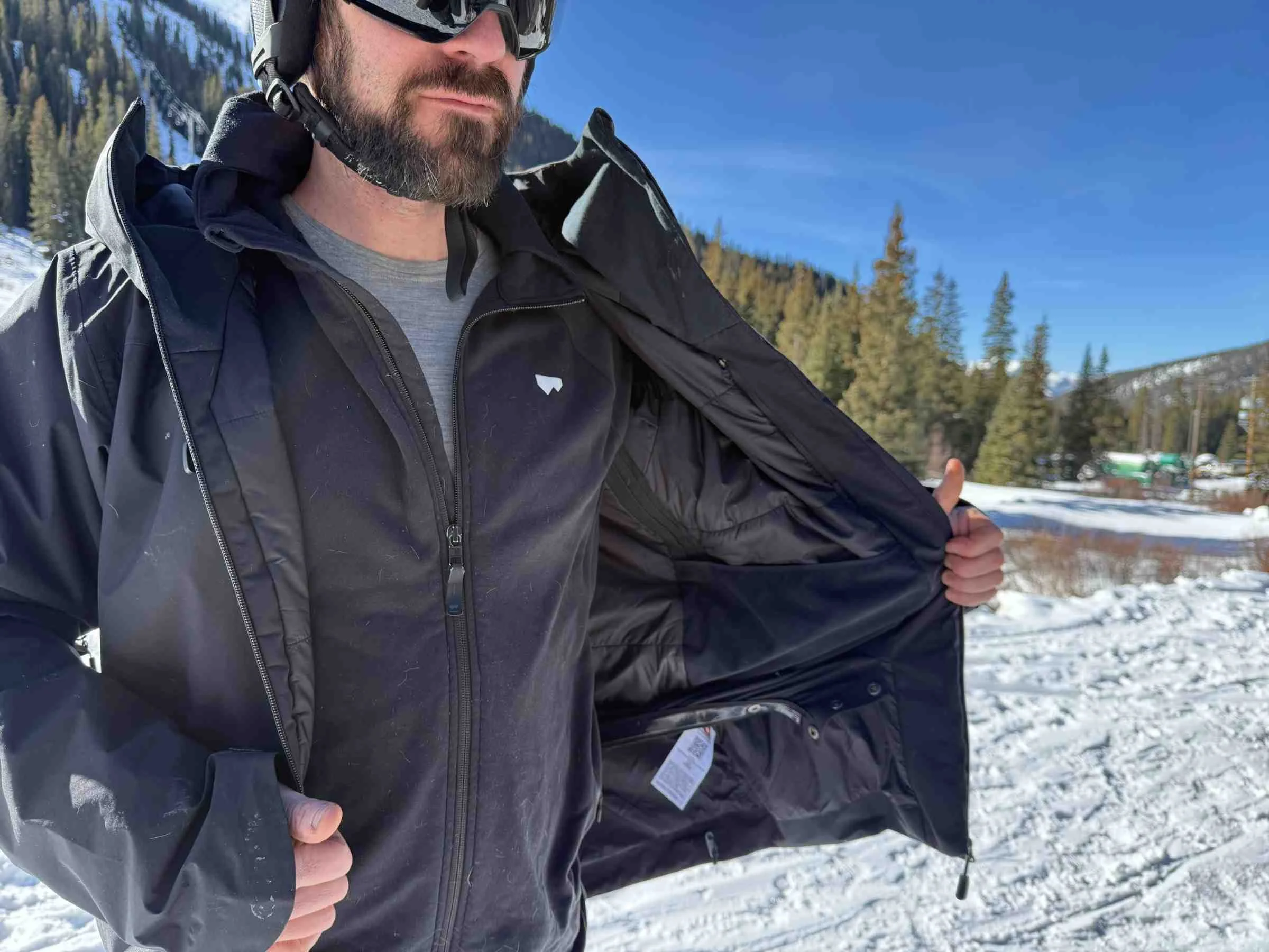   Man opening Norrona Lofoten GORE-TEX Insulated ski jacket to show interior  