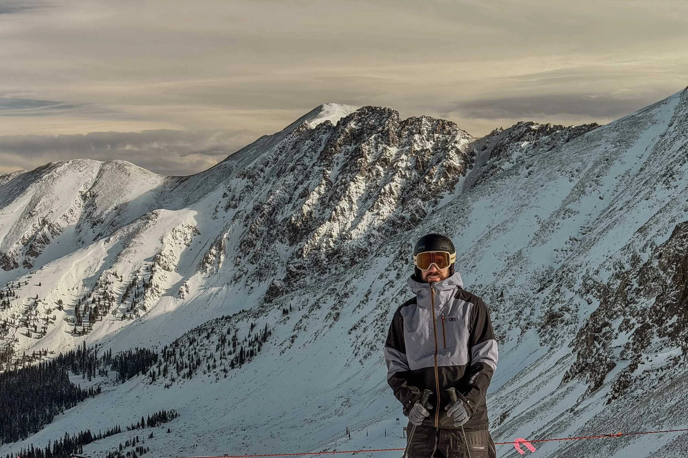   Man standing on ridgeline wearing Outdoor Research Hemispheres jacket  