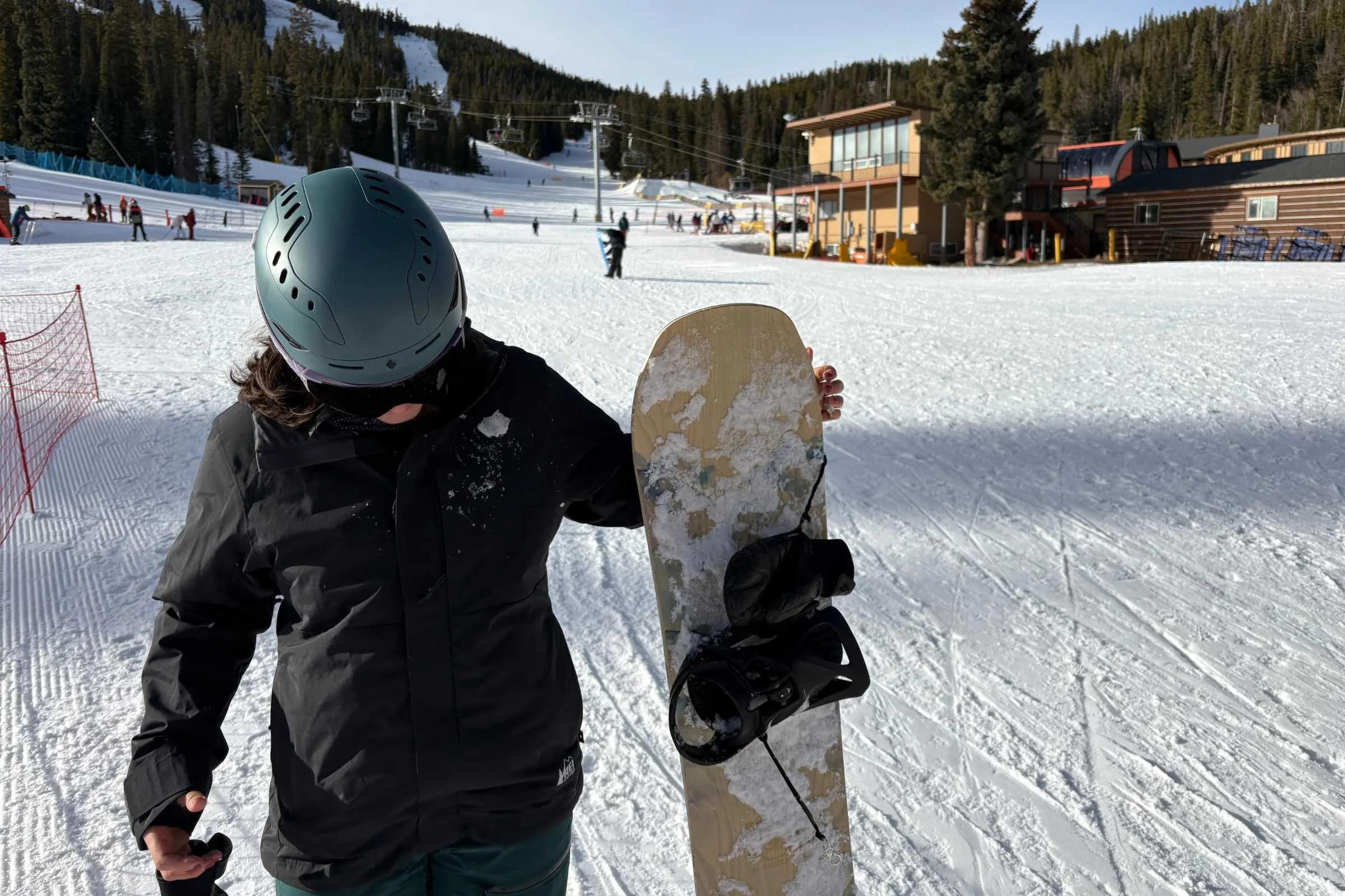   Snowboarder holding board wearing REI Co-op Powderbound Insulated Jacket  