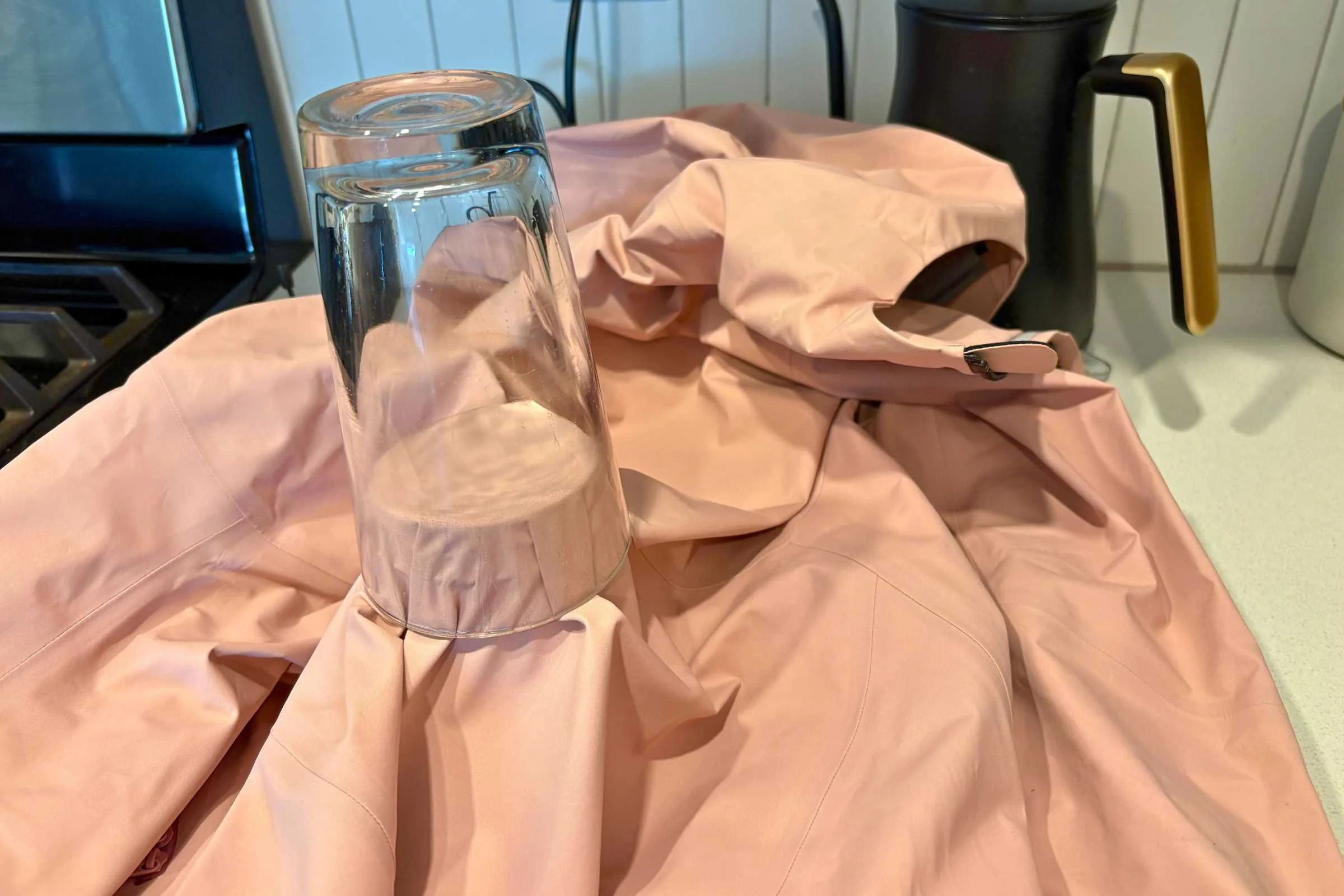   Upside-down glass of water on ski jacket fabric during waterproof test    