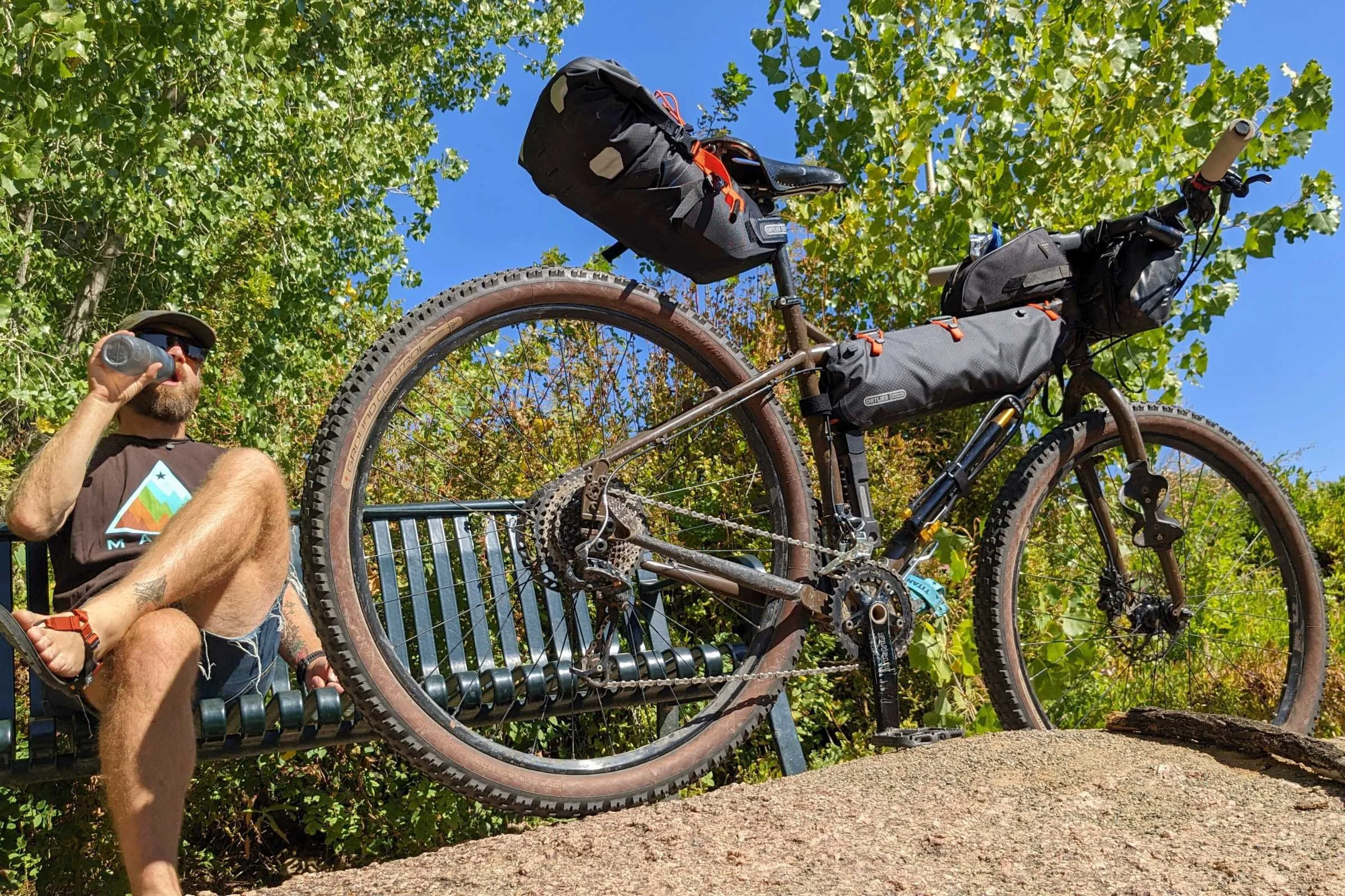   Taking a break with a loaded bike. The Ortlieb Seat pack conical roll-top dry bag is on the back of the bike.  