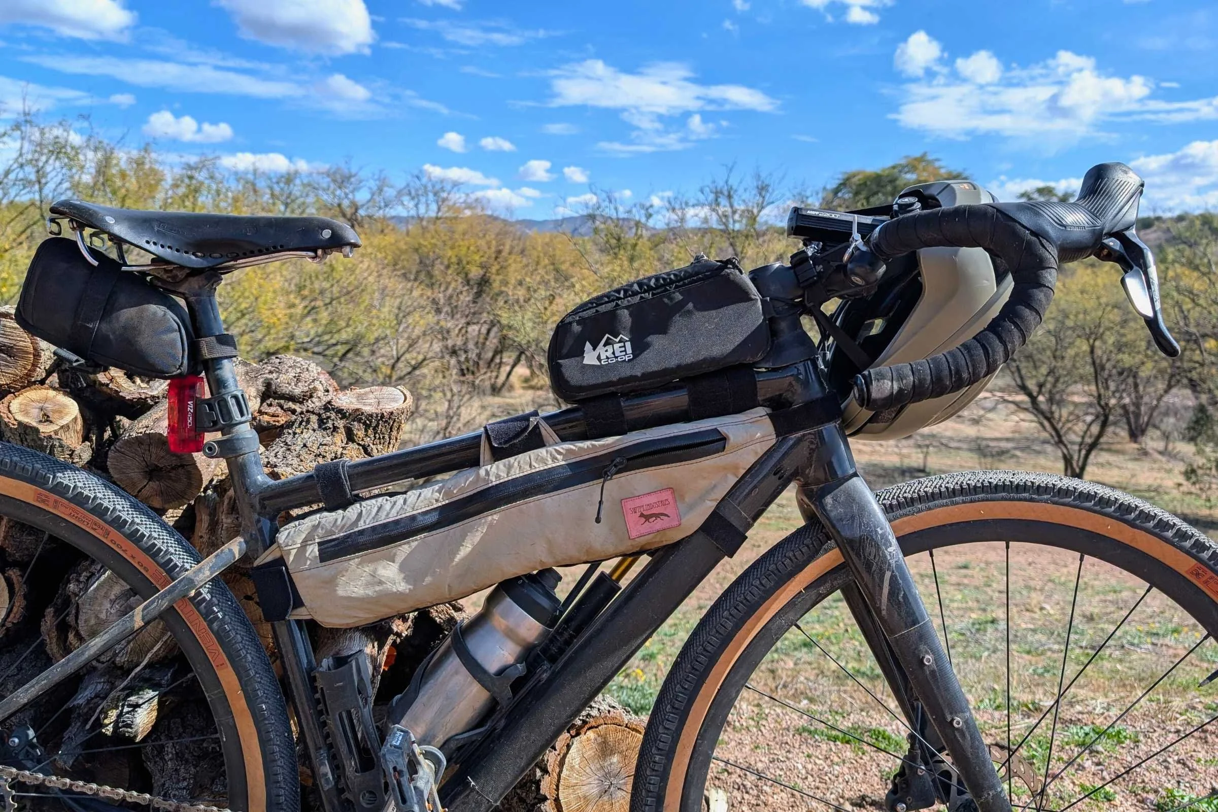   REI Co-op Junction Top Tube Bag mounted on the top tube of a gravel bike near the handlebars.  
