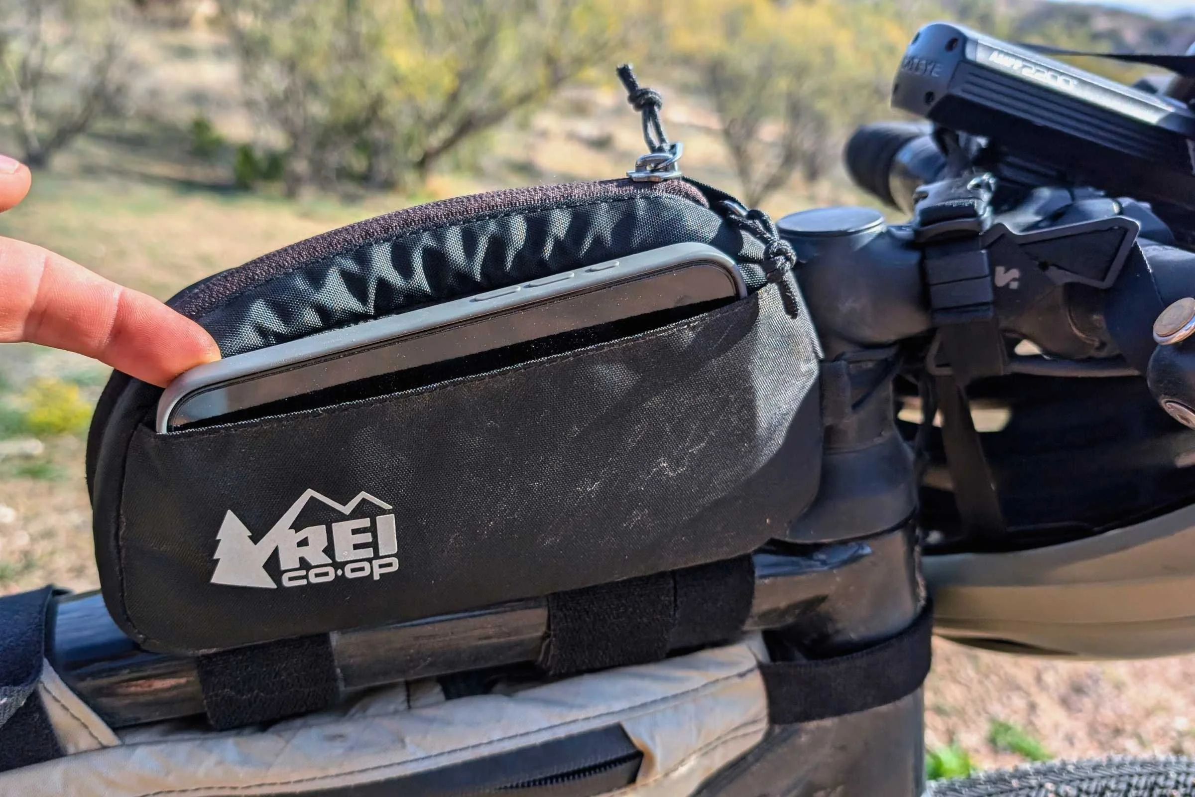   A close-up of the REI Co-op Junction Top Tube Bag showing the zipper opening and REI Co-op branding.  
