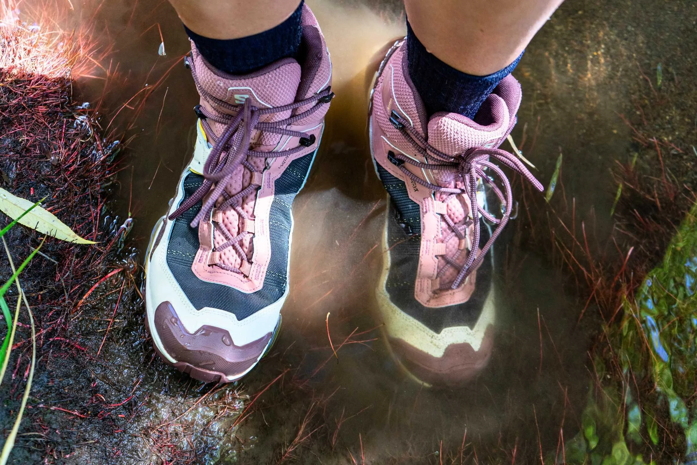   A top-down view of the Salomon X Ultra 5 Mid GTX hiking boots standing in water, showing waterproof protection  