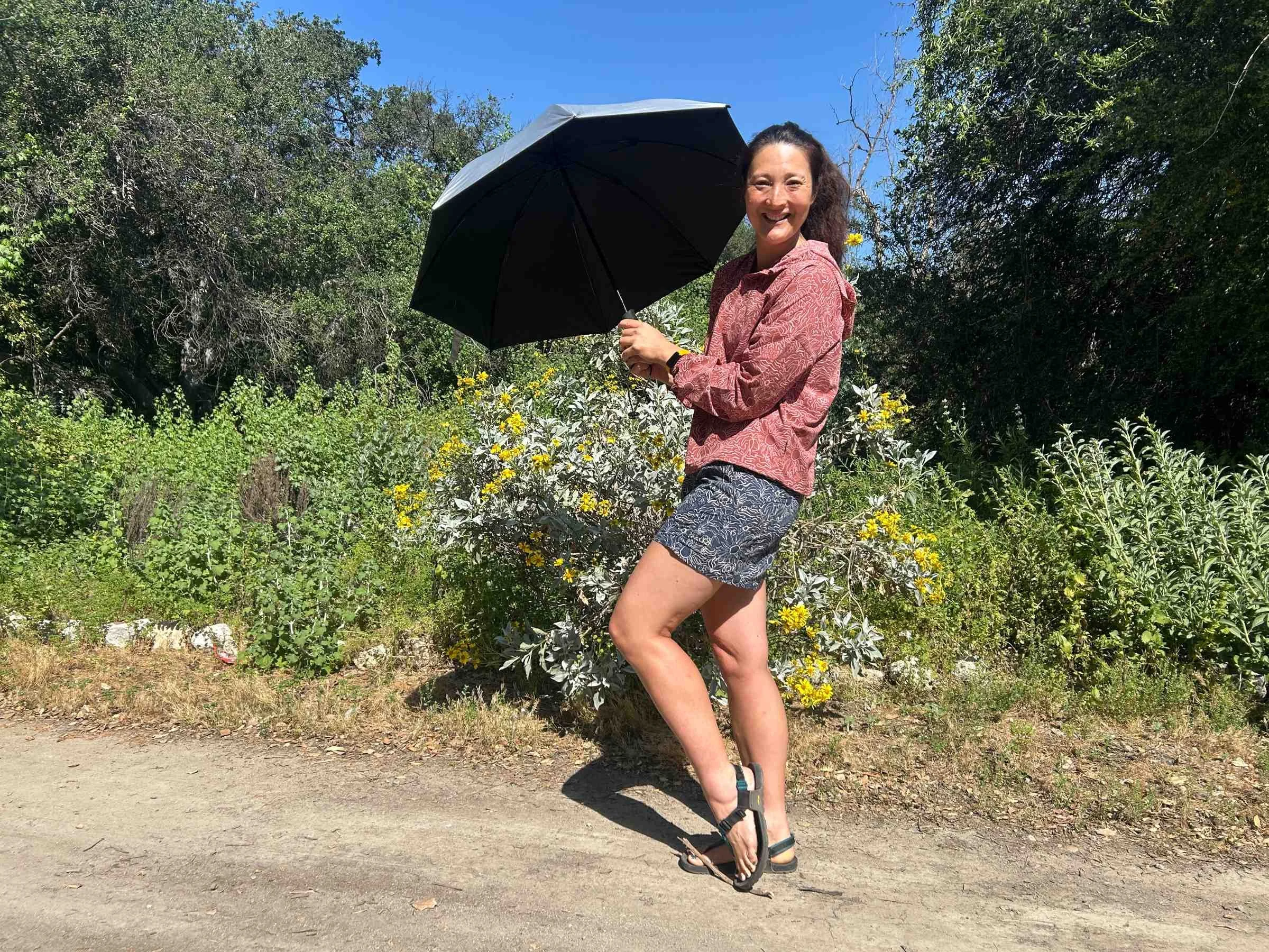   The author Liz Thomsa with the Six Moon Designs Silver Shadow umbrella. She found it has a sizable canopy that can block out the sun on hot days.  