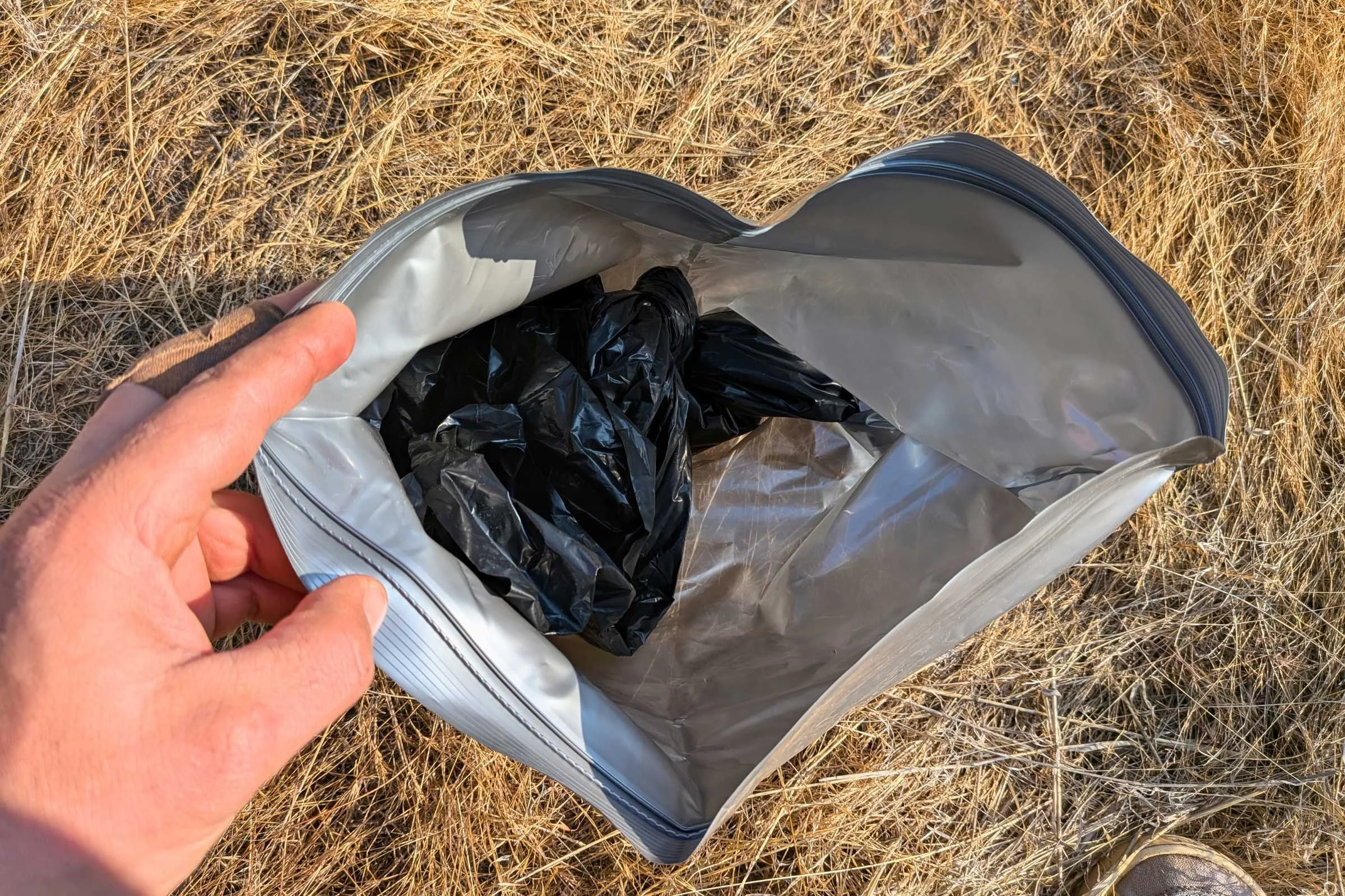   Close-up view inside the Camco toilet waste bag showing the inner waste bag secured inside the outer zip disposal bag.  