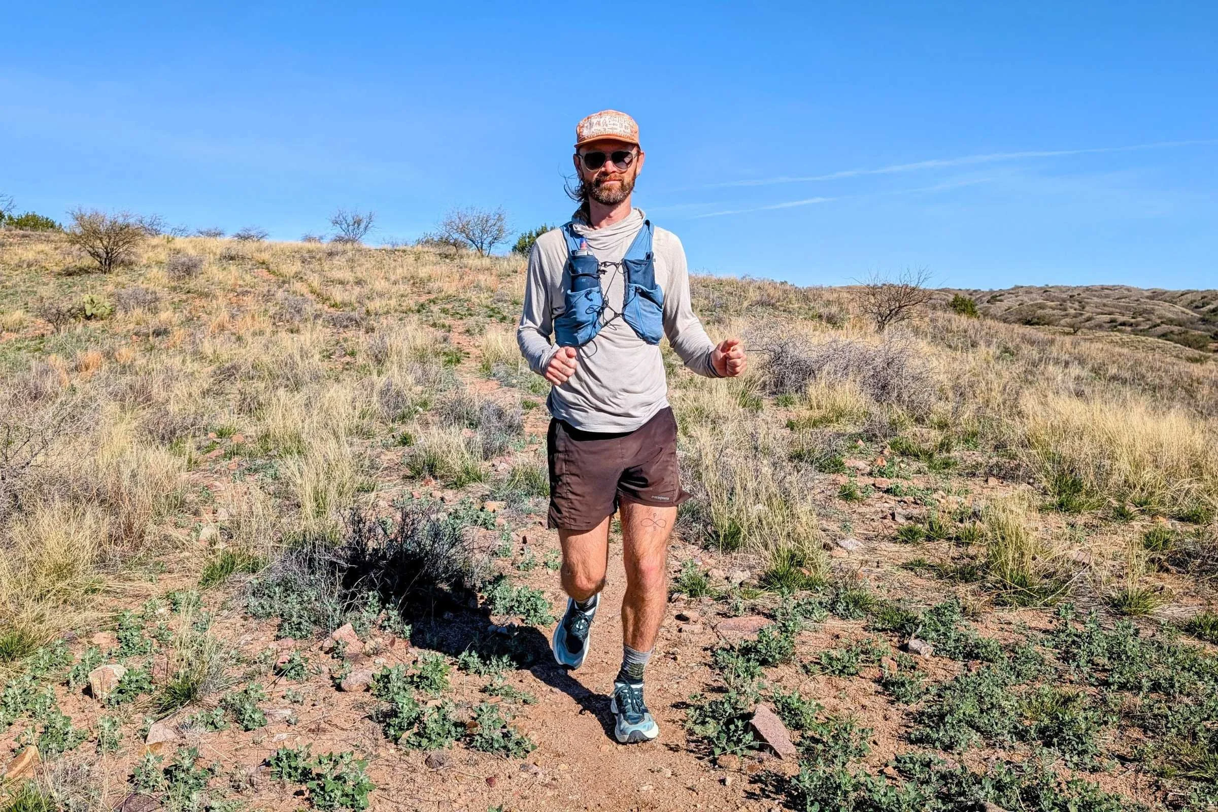   Runner on a dry desert trail wearing HOKA Speedgoat 7 trail running shoes.  