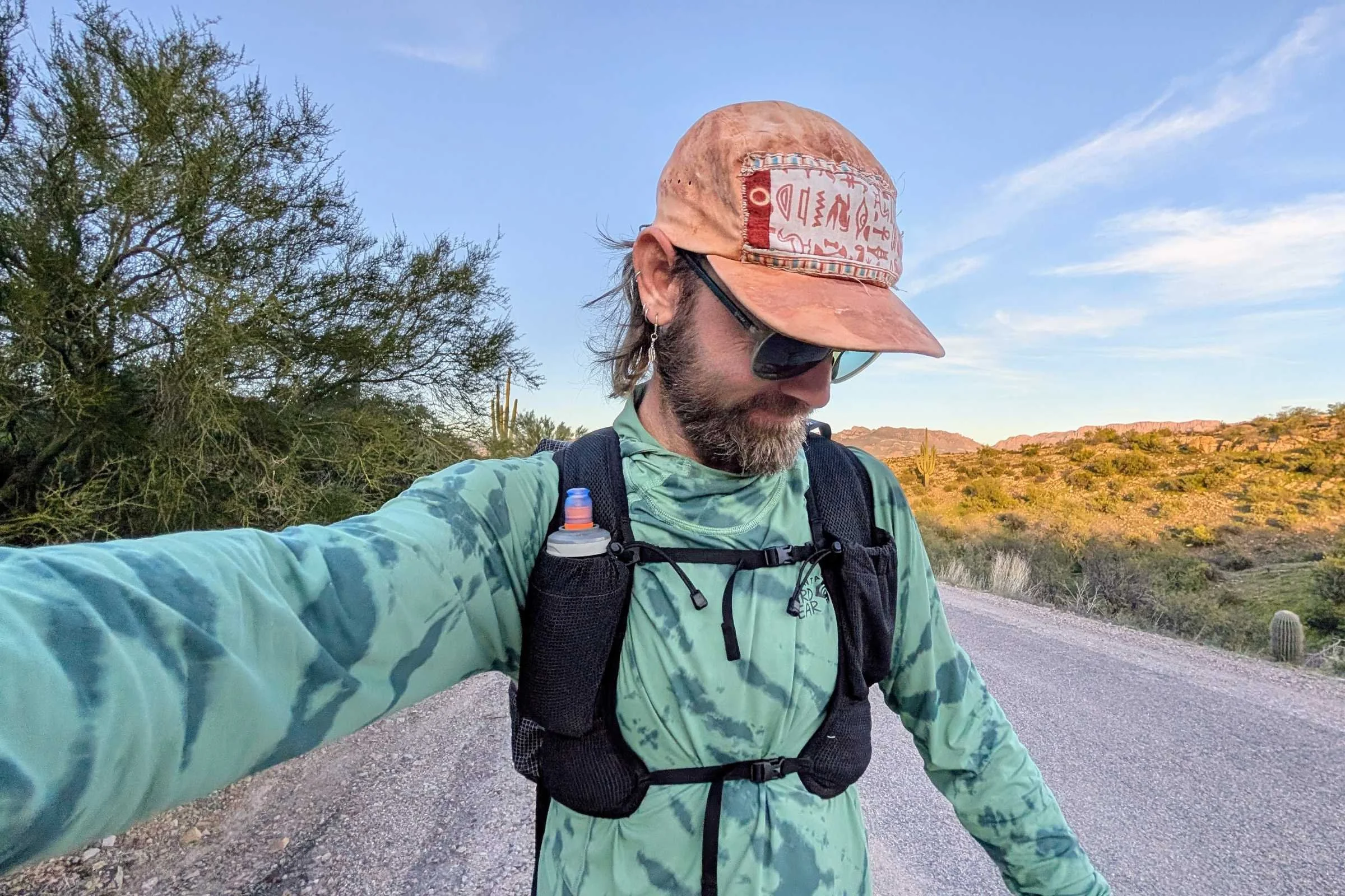   Runner wearing the Pa’lante Packs V2 with Joey Straps showing front harness fit and chest pockets while on a road.  