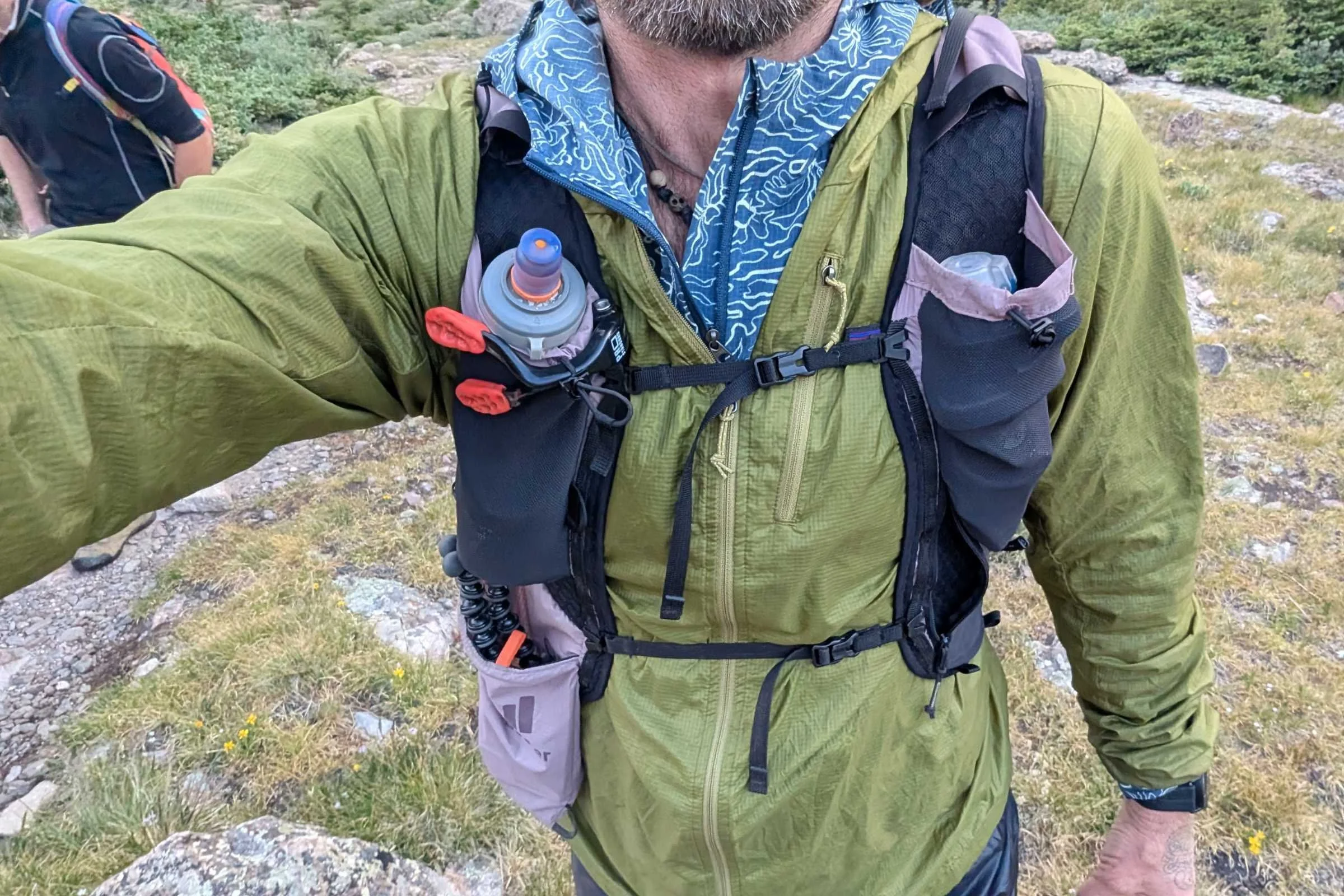   Front view of the Deuter Ascender 13 running pack showing harness fit and front storage pockets with soft flasks.  