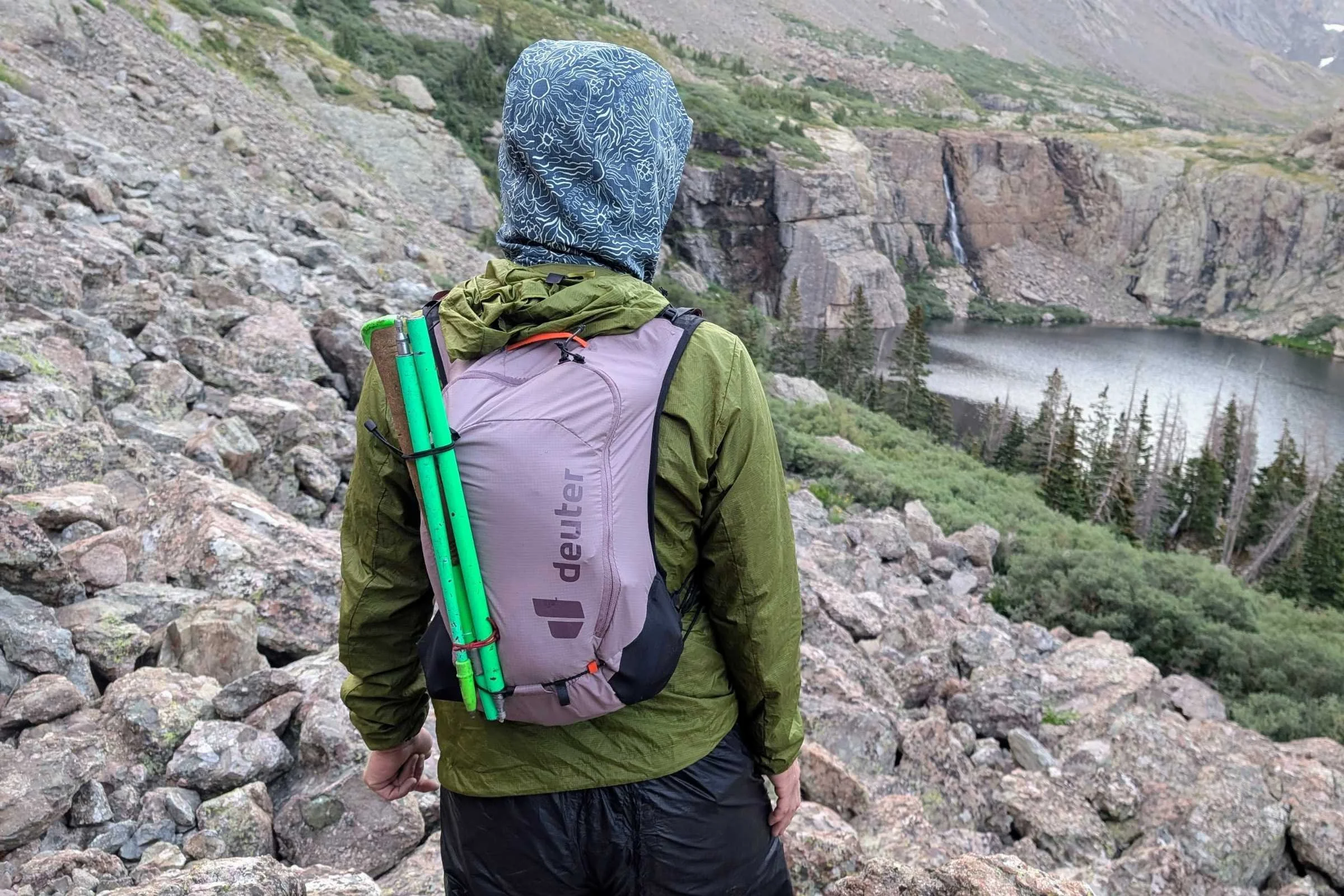   Rear view of a runner wearing the Deuter Ascender 13 running pack on rocky mountain terrain.  