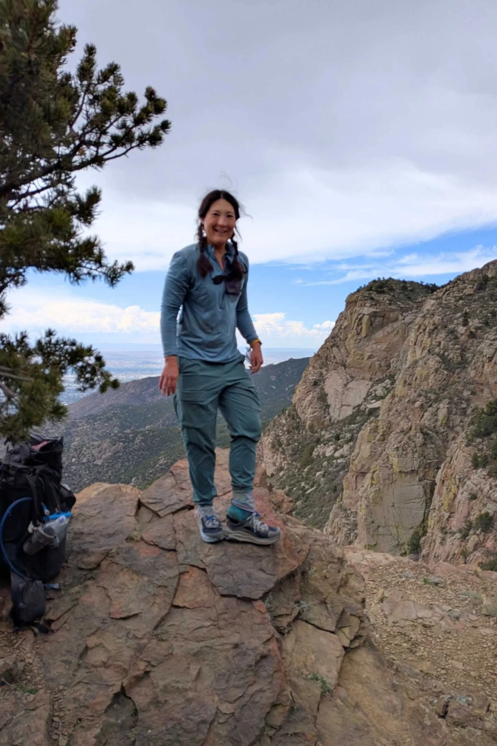   Hiker standing on rocky terrain wearing REI Trailmade Pull-On pants.  