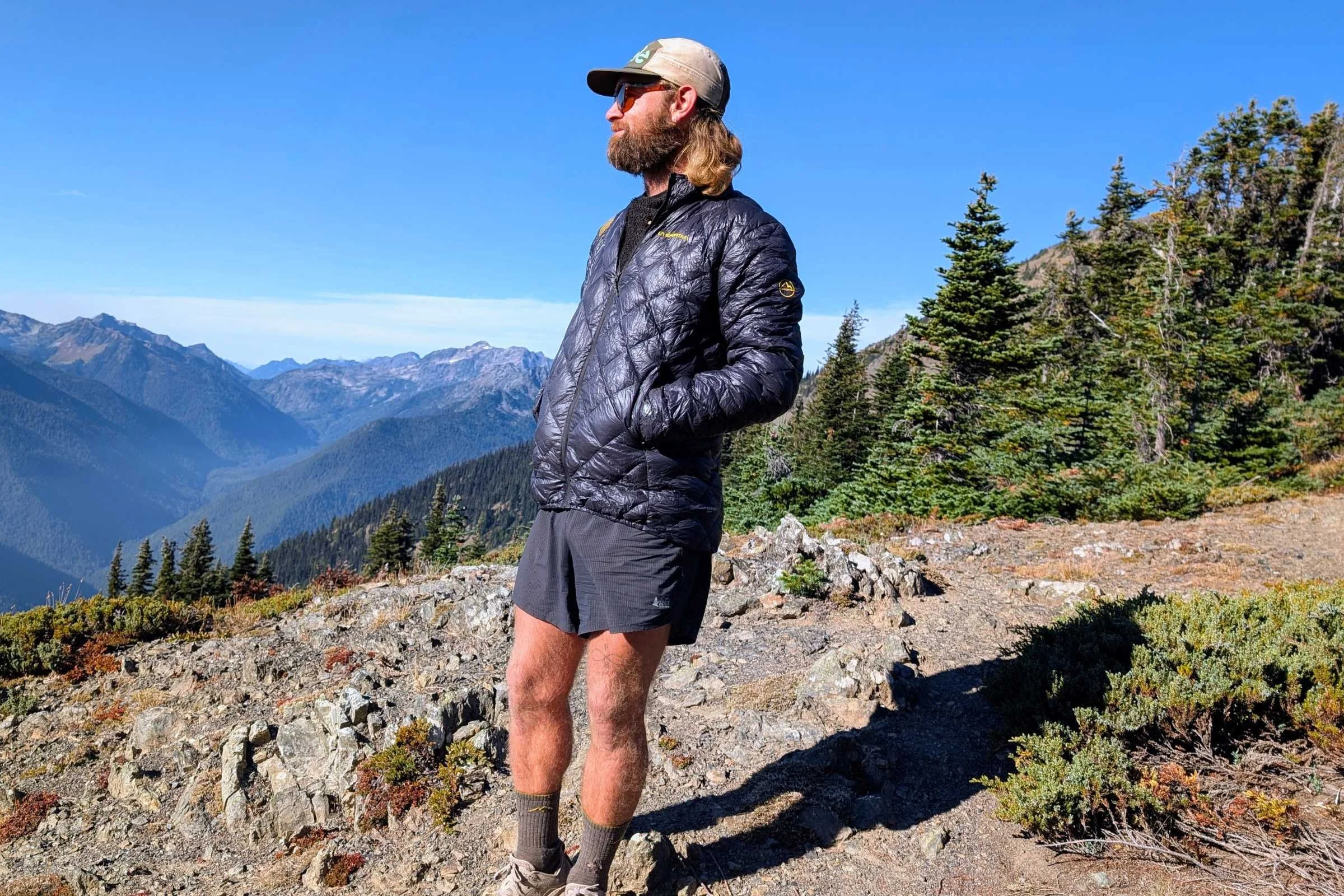   Man standing on a mountain trail wearing REI Co-op Swiftland 5-inch Running Shorts.  