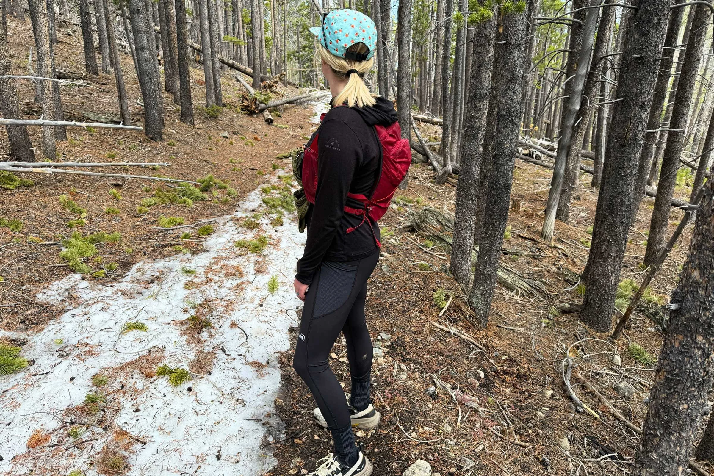   Rear view of a woman on a forest trail wearing REI Co-op Swiftland 7/8 Running Tights.  
