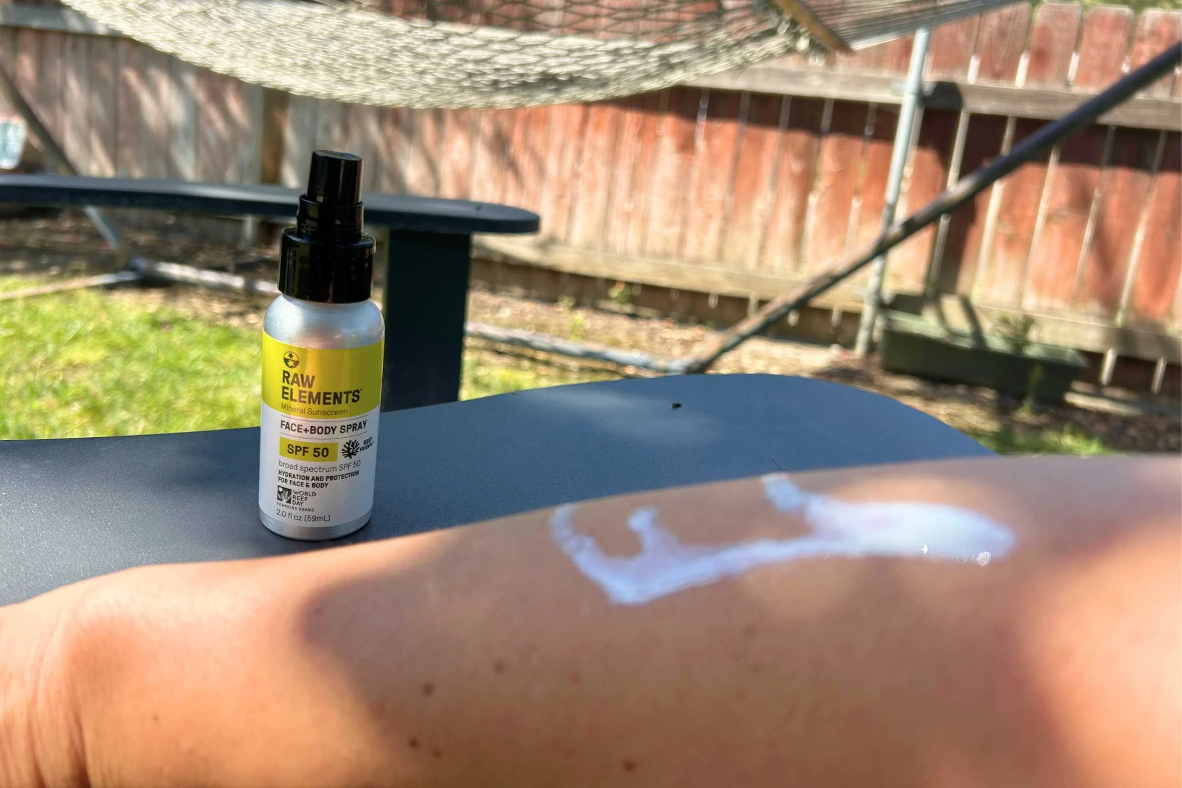   Raw Elements SPF 50 mineral sunscreen spray applied to skin during outdoor sunscreen testing  