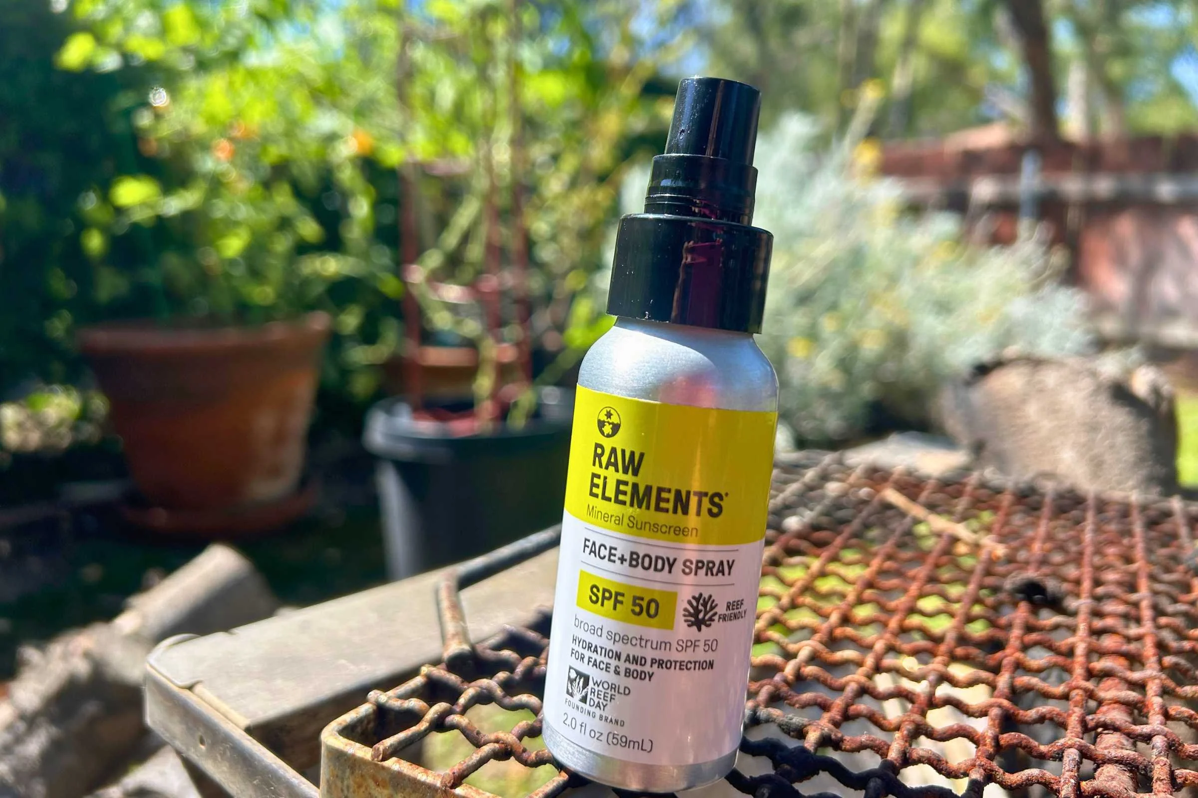   Raw Elements SPF 50 mineral spray sunscreen bottle on outdoor patio table during gear testing  