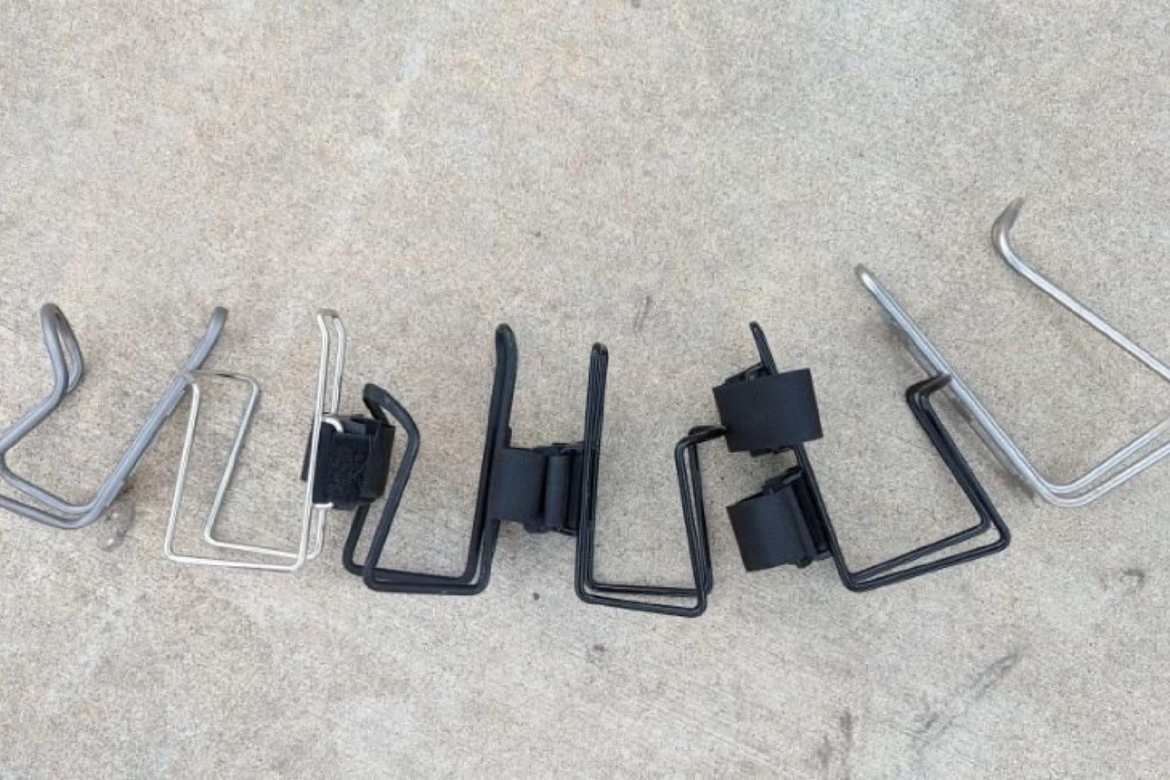  Water bottle cages with similar design. Left to right: Silca Sucuro,&nbsp;TwoFish quick cage stainless steel,&nbsp;Planet Bike Aluminum,&nbsp;TwoFish quick cage vinyl coated,&nbsp;TwoFish quick Cage 40 oz,&nbsp;Widefoot Litercage  