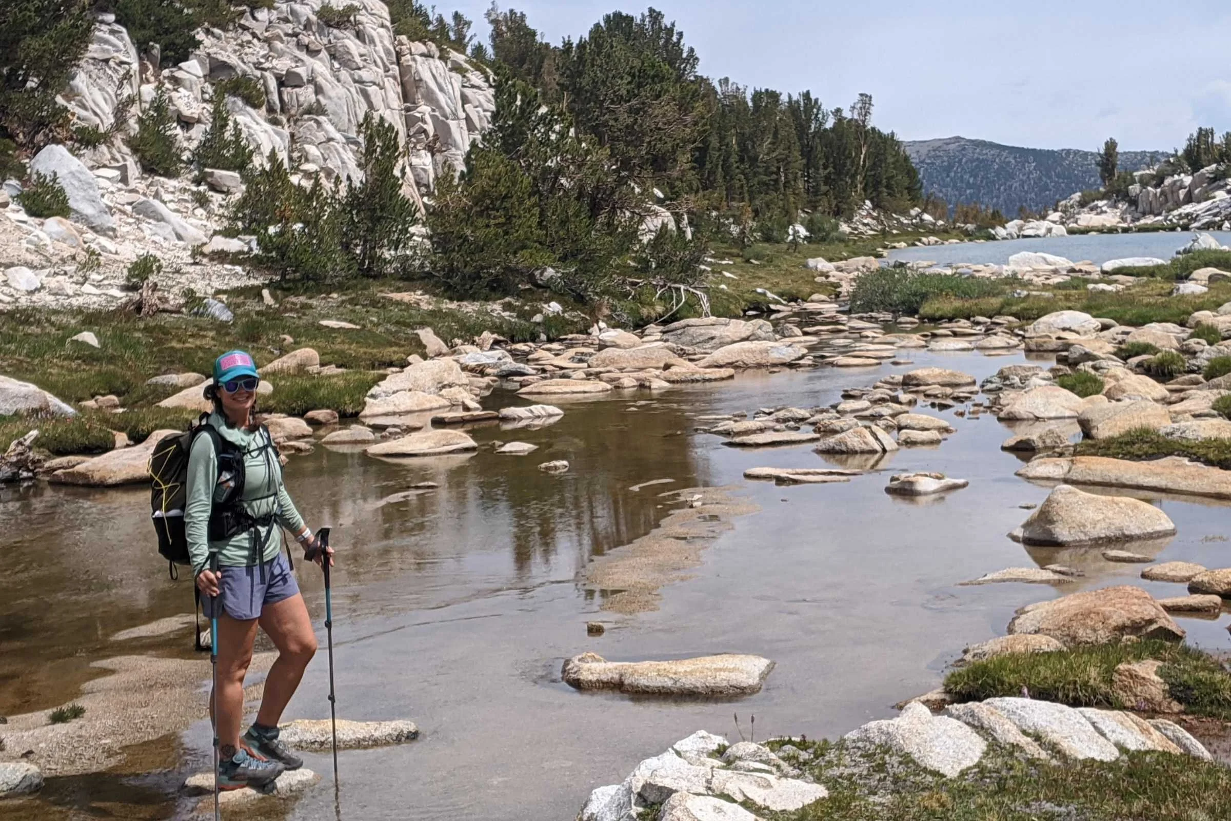   Hiker wearing Injinji Trail Midweight socks while crossing alpine stream during backpacking trip  