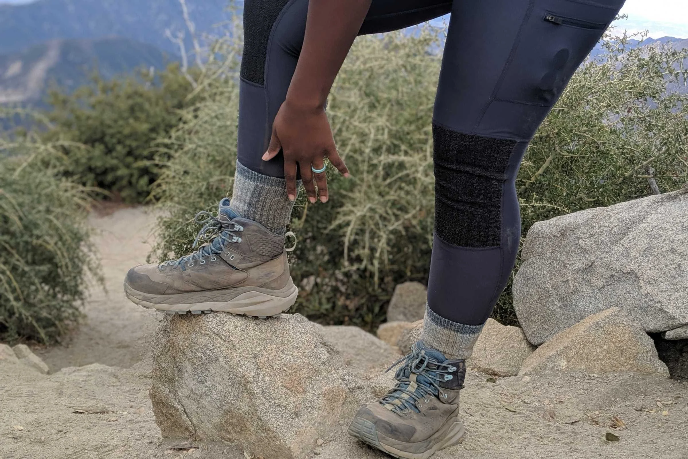   Hiker wearing REI Co-op Merino Wool Lightweight Hiking Crew Socks with hiking boots on rocky trail  