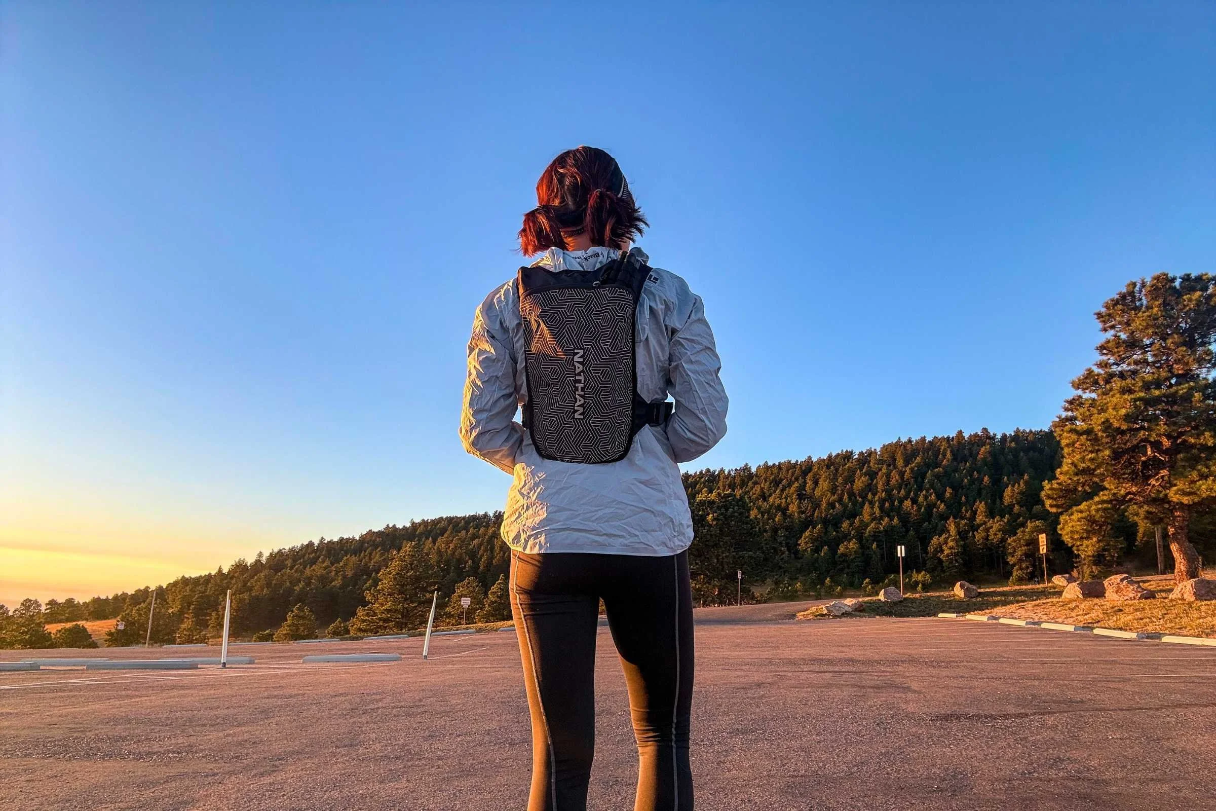   Rear view of runner wearing Nathan HyperNight QuickStart 3.0 hydration pack at sunrise  