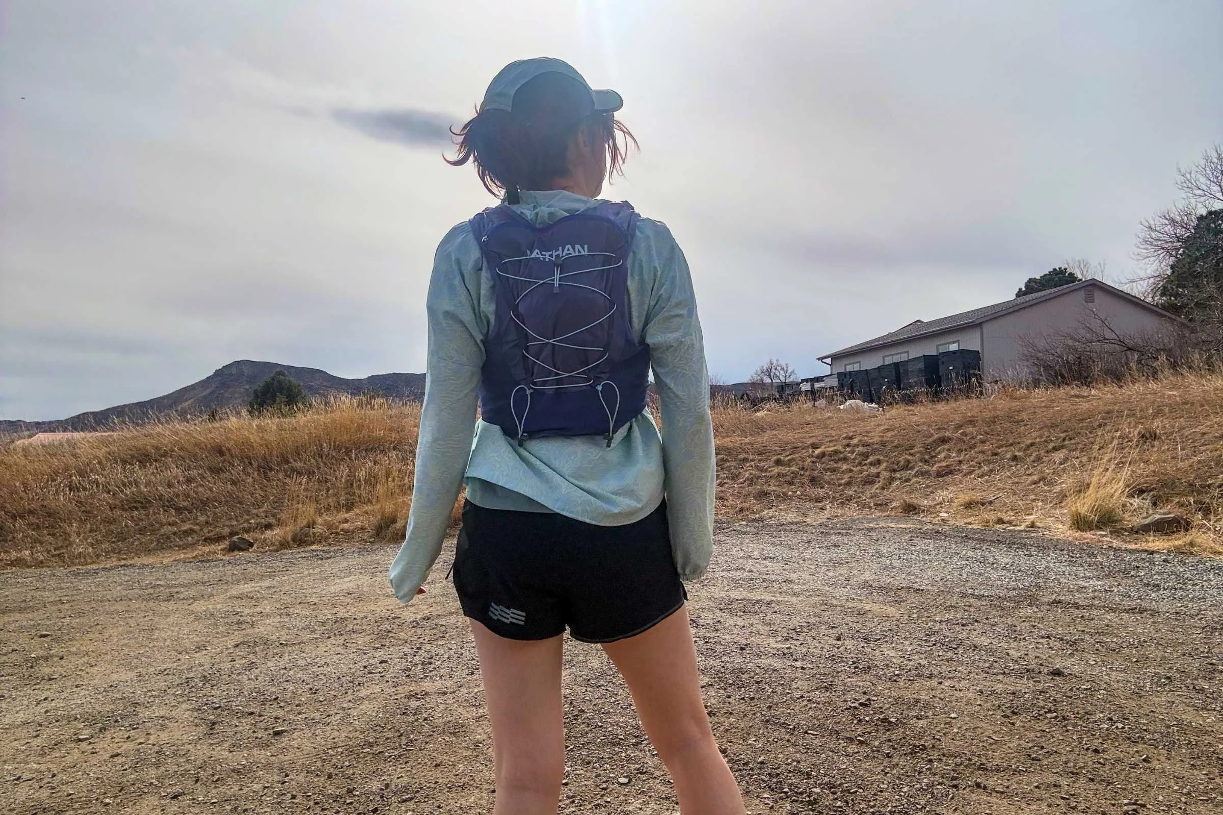   Rear view of runner wearing Nathan VaporAiress 4.0 hydration vest showing back panel fit and storage capacity  