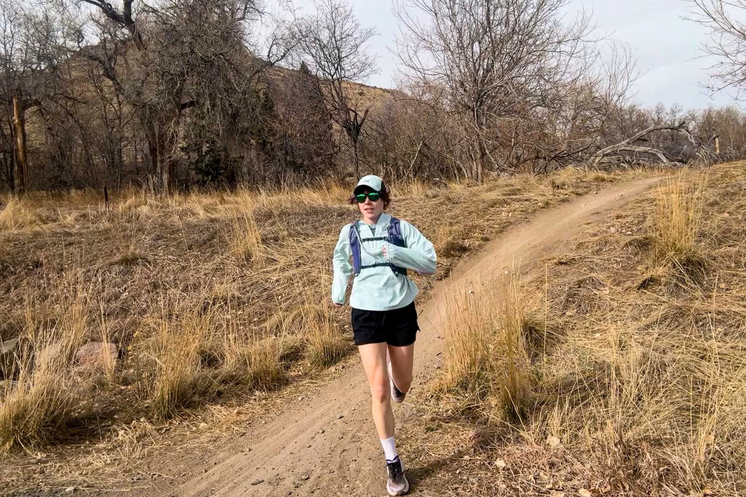   Runner wearing Nathan VaporAiress 4.0 hydration vest on singletrack trail during testing  