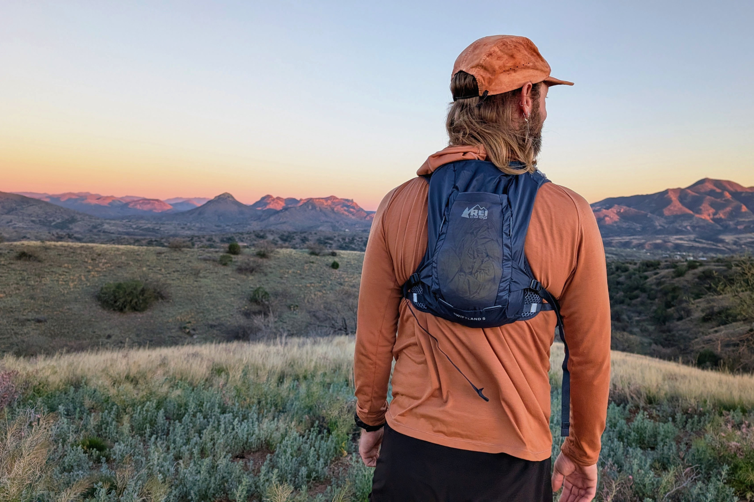   The author pausing during a sunset trail run wearing the REI Co-op Swiftland 5 hydration pack in black  