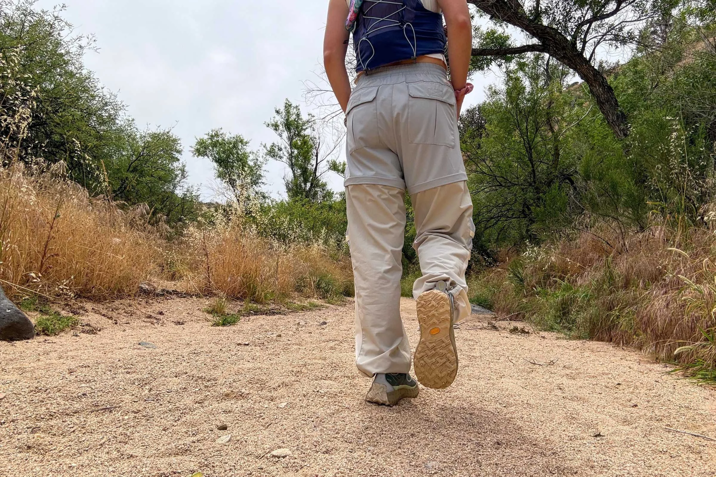   Rear view of hiker wearing norda 001 trail running shoes showing off the tread on a sandy trail  