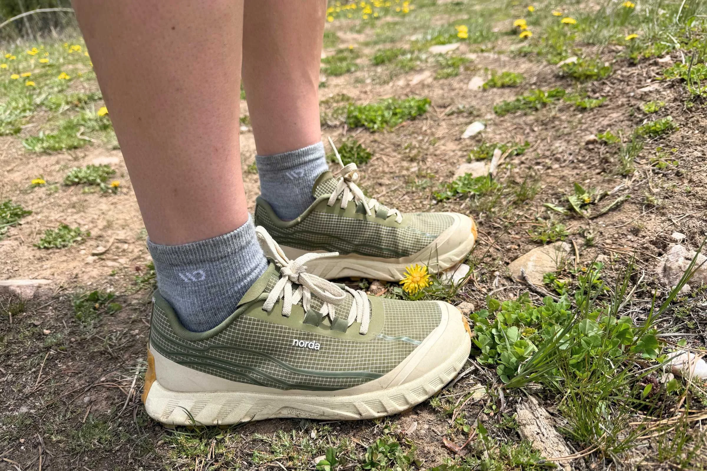   Side view of hiker wearing norda 002 trail running shoes on dirt trail  