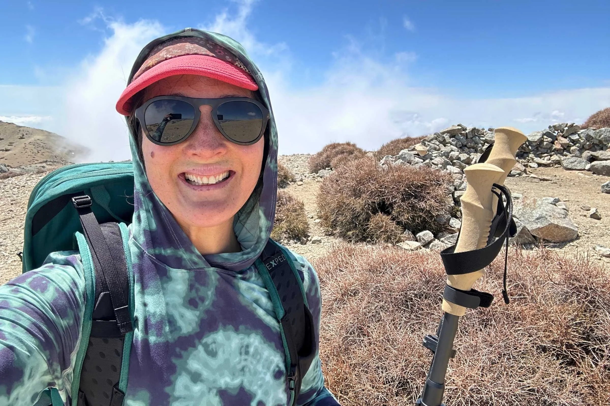   Woman wearing Mountain Hardwear Crater Lake Hoody while backpacking above treeline  