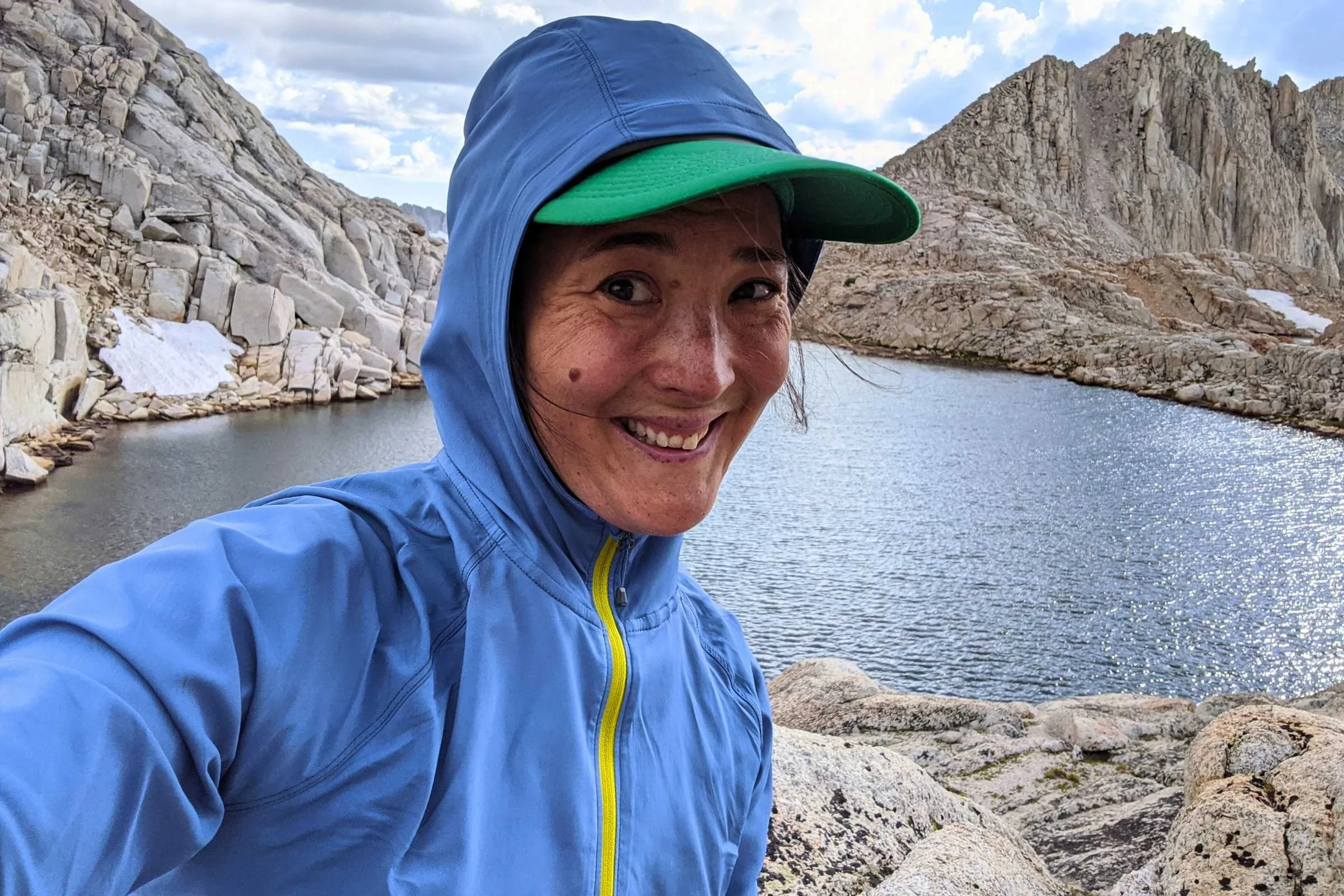   Woman wearing Outdoor Research Astroman Sun Hoodie beside alpine lake  