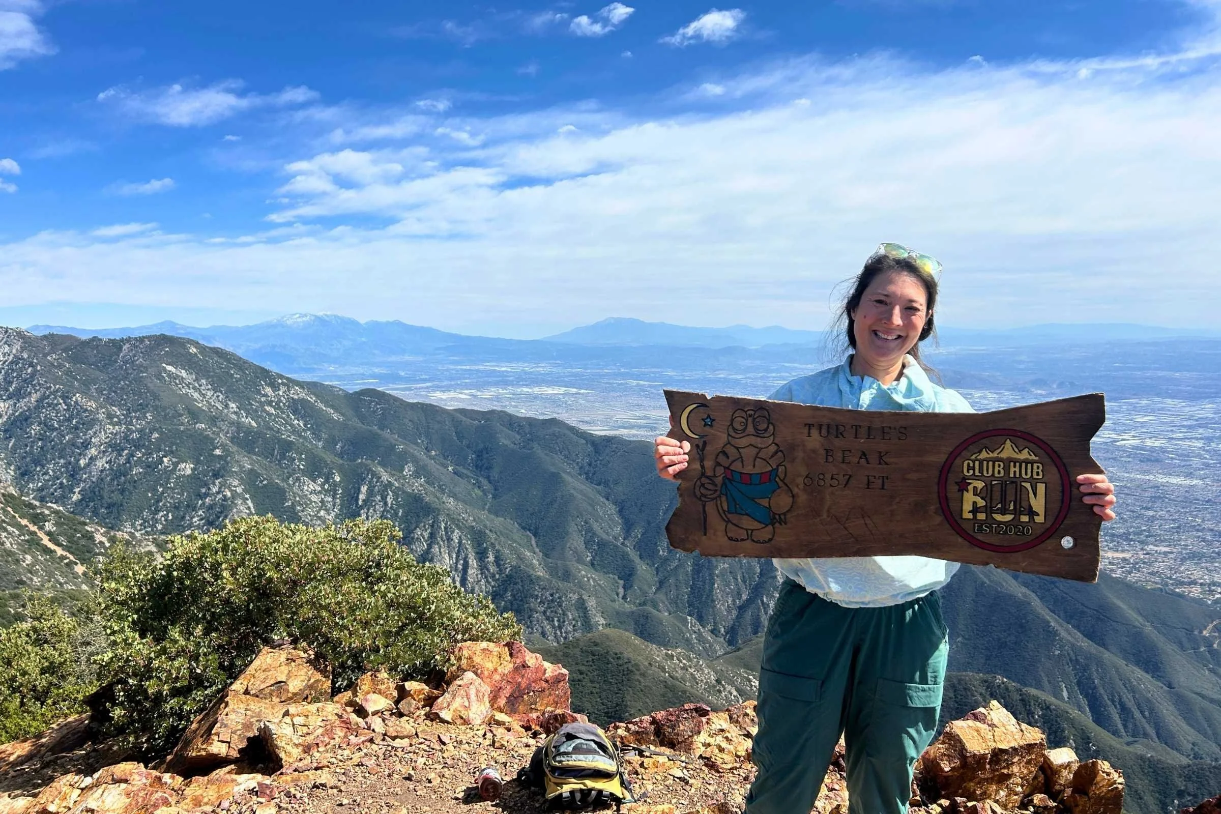   Woman wearing Royal Robbins Salathe Sun Shirt sign at the peak of a mountain  