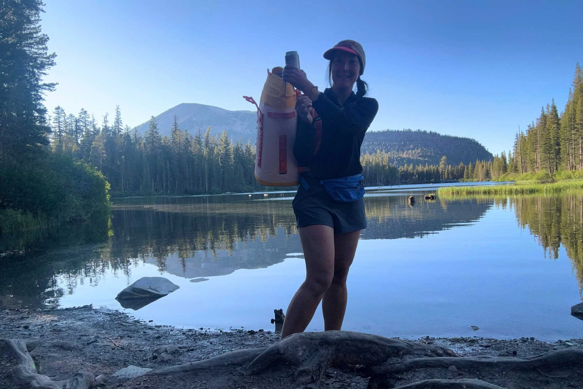   Woman wearing The North Face Sunriser Sun Hoodie beside alpine lake at sunset  