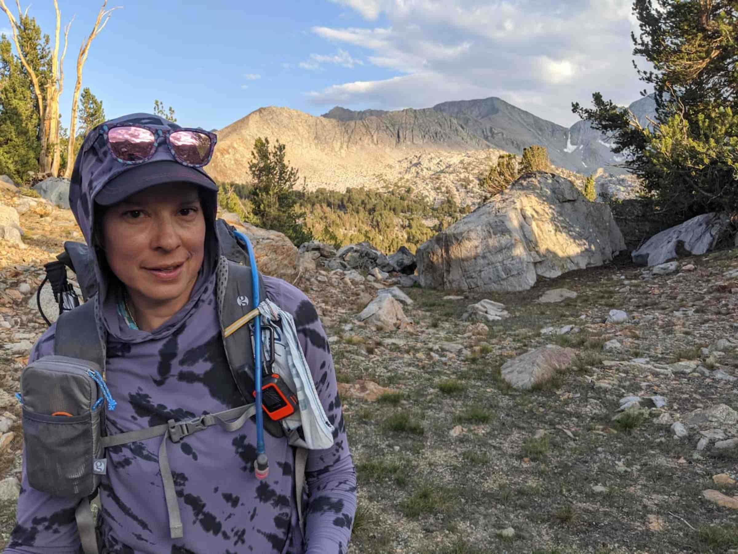   Backpacker wearing Mountain Hardwear Crater Lake Hoody on a rocky trail  
