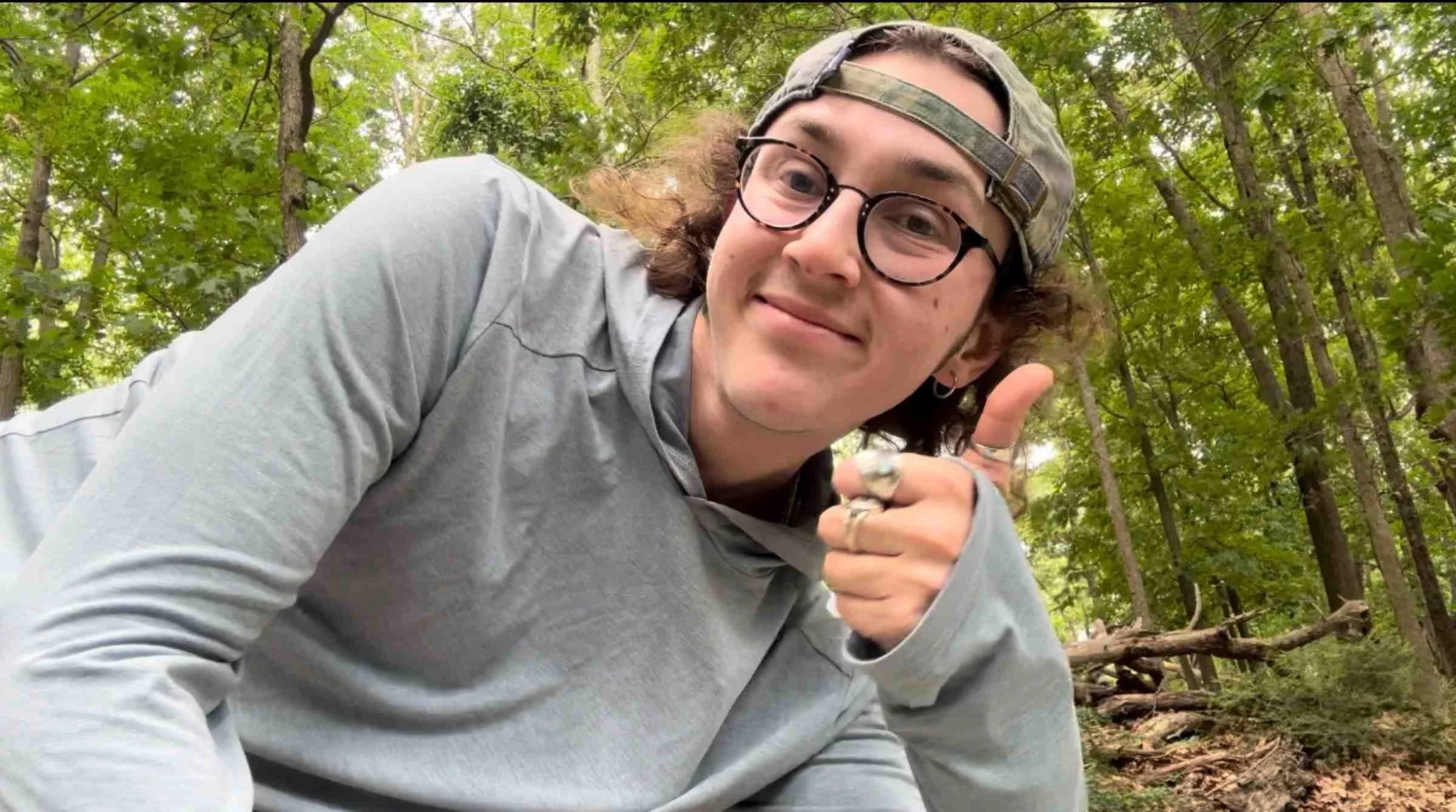   Close-up of person wearing Free Fly Shade Hoodie in forest setting  