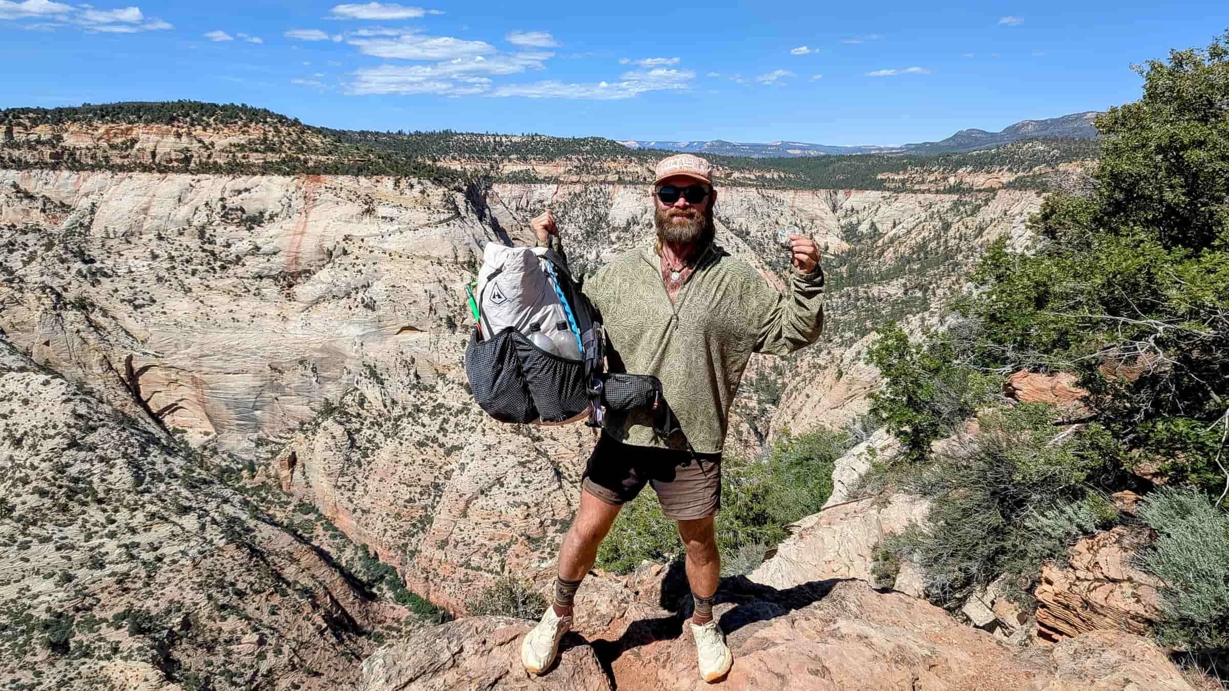   Person wearing Royal Robbins Salathe Sun Shirt at a canyon overlook with backpack and hiking gear  