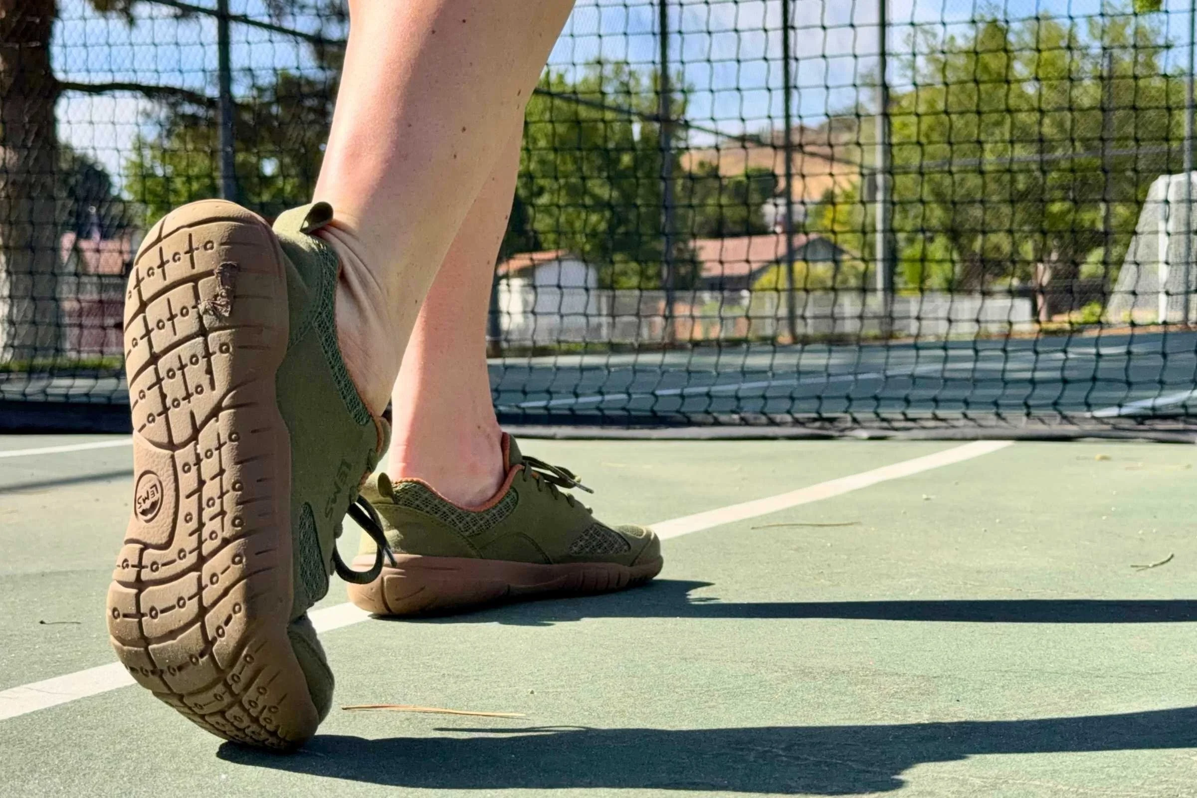   Person wearing Lems Primal 3 barefoot shoes on a pickleball court  