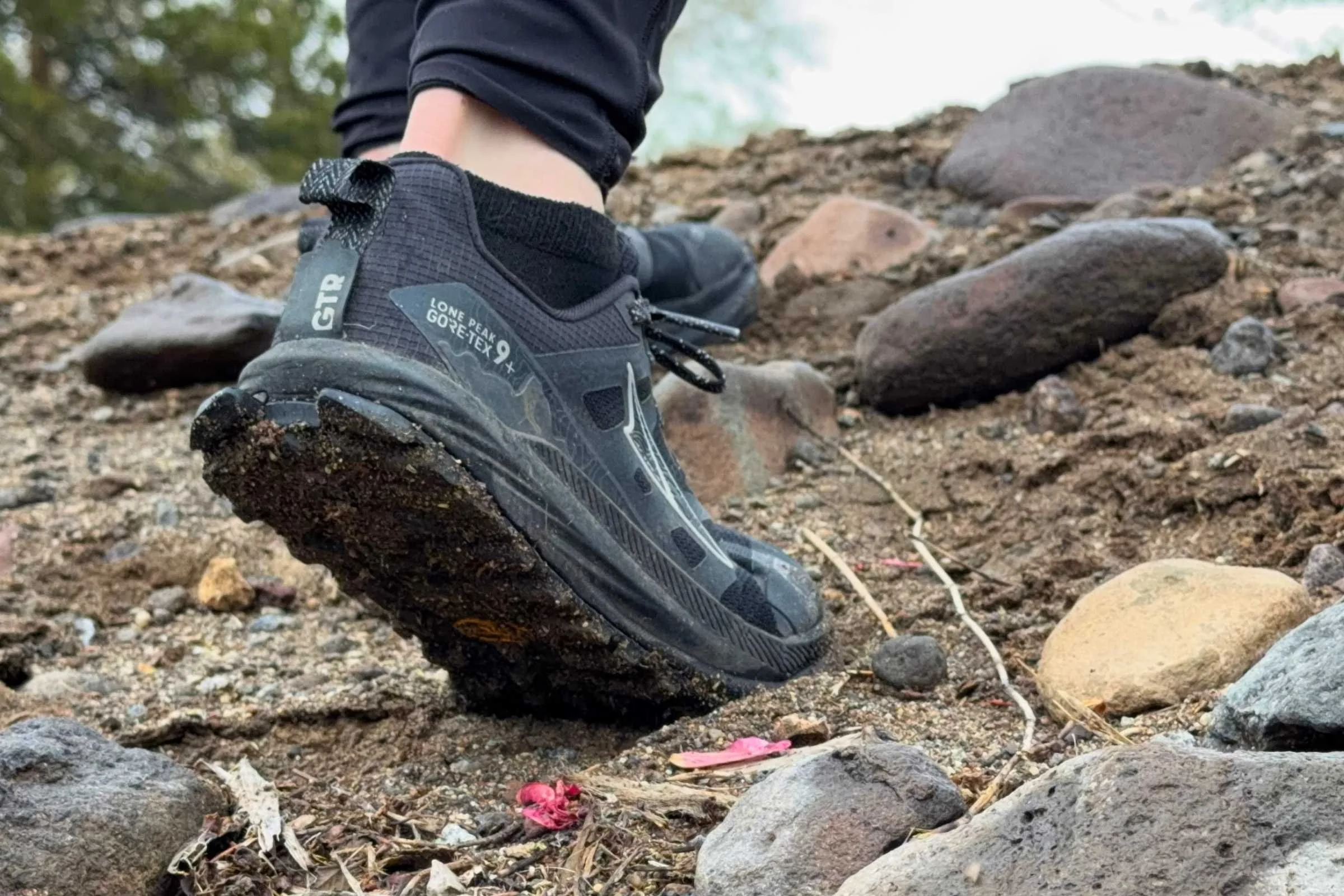   Altra Lone Peak 9+ trail running shoe on rocky terrain showing outsole traction  