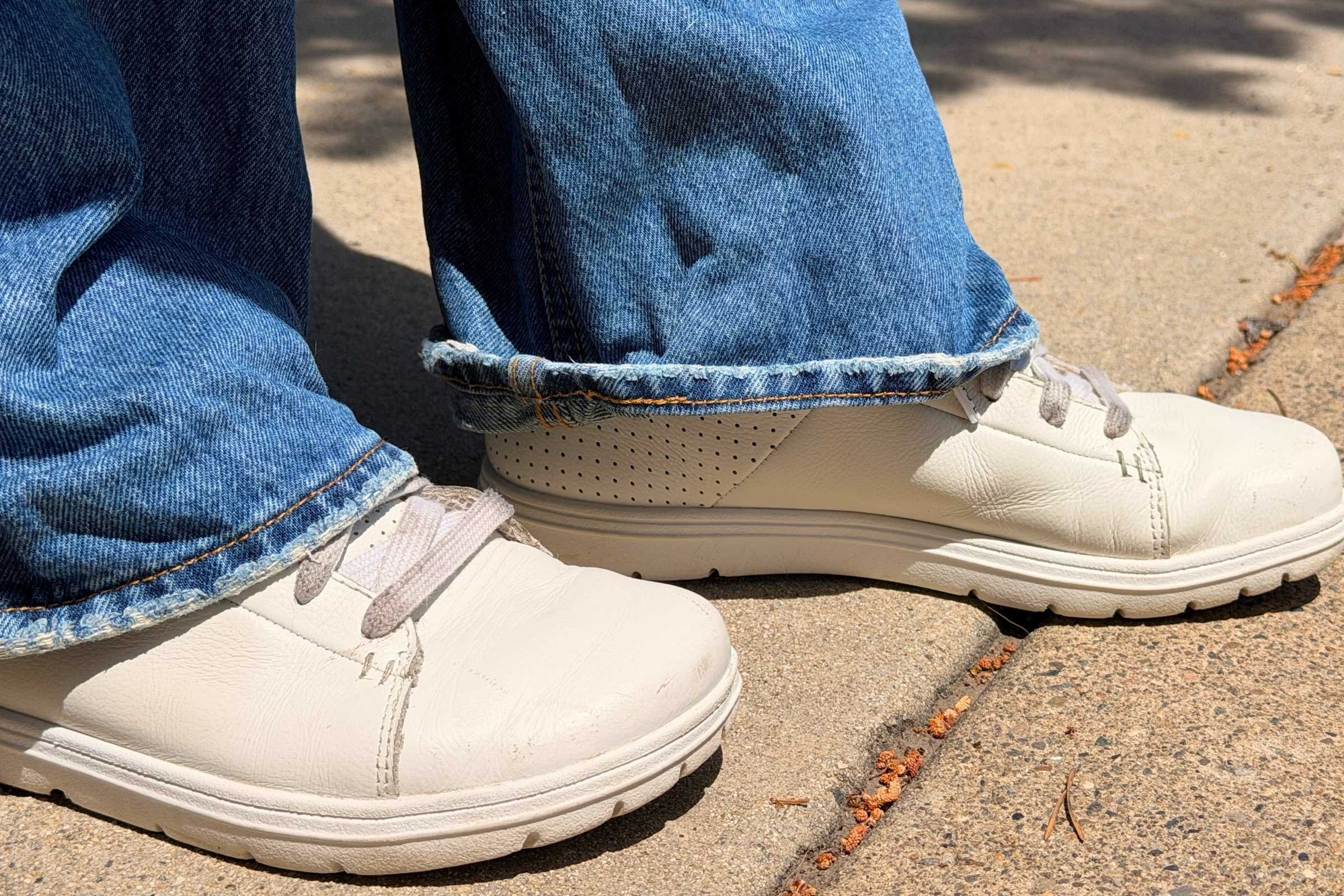   Person wearing Lems Kourt barefoot shoes with jeans on pavement  
