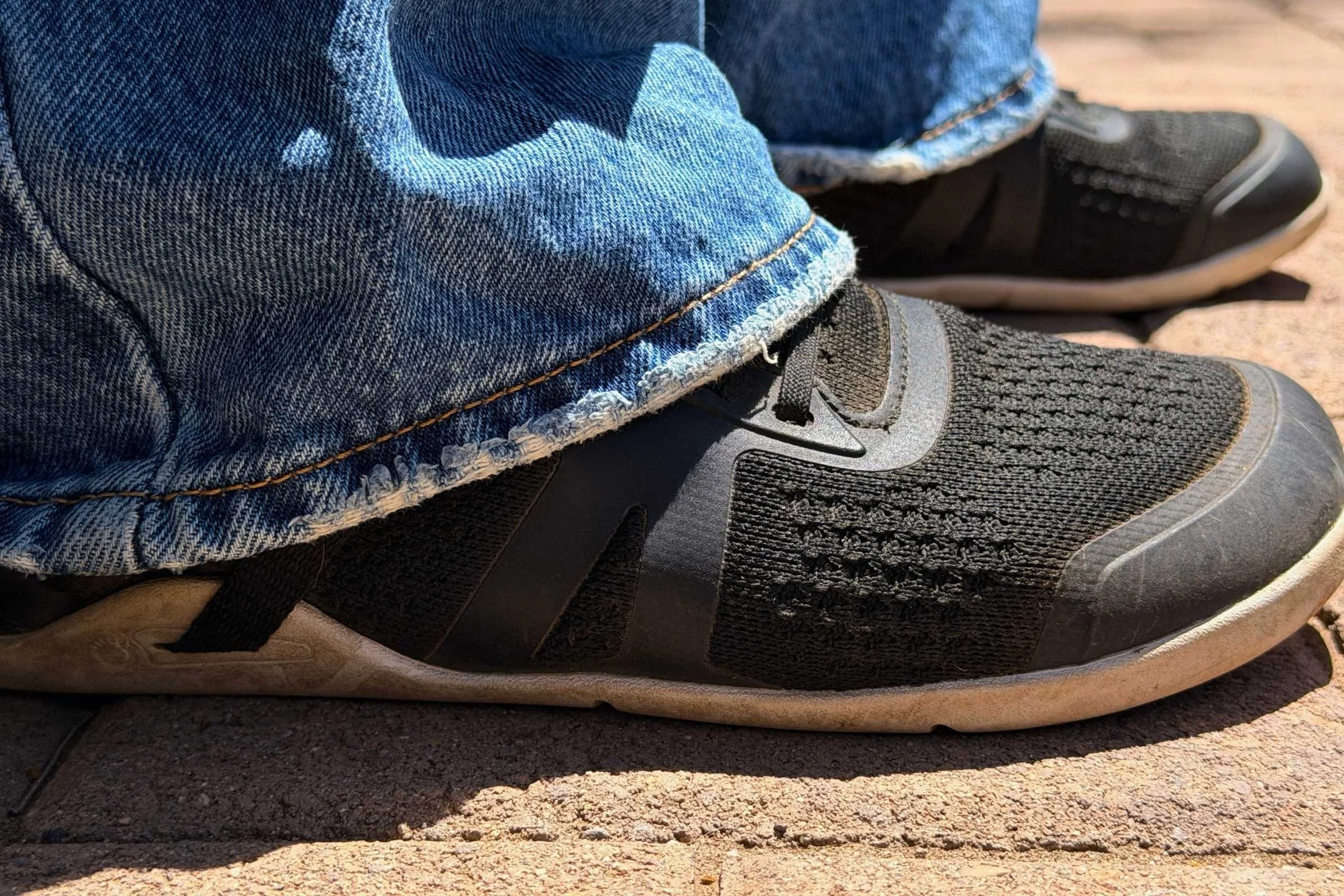  Person wearing Xero Shoes Prio Neo barefoot shoes with jeans on pavement  