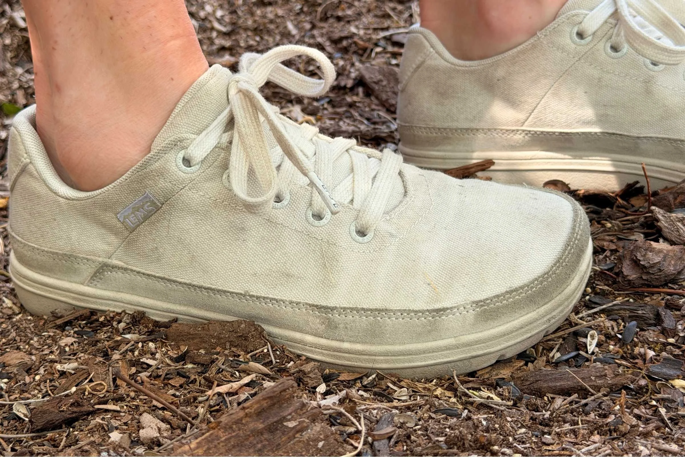   Person wearing Lems Chillum barefoot shoes on mulch-covered ground  