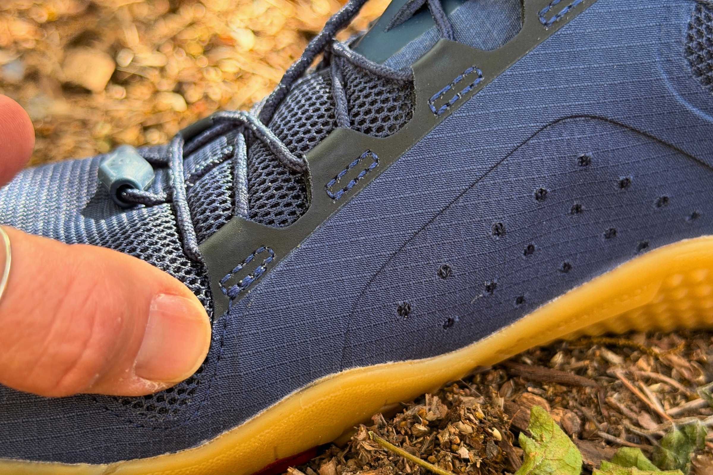   Close-up of Vivobarefoot Primus Lite 3.5 upper and mesh material.  Here, the author is pointing to the end of a stiffening rod that runs down the in-step, preventing feet from being able to expand in the toe box (adding to the very narrow feeling).