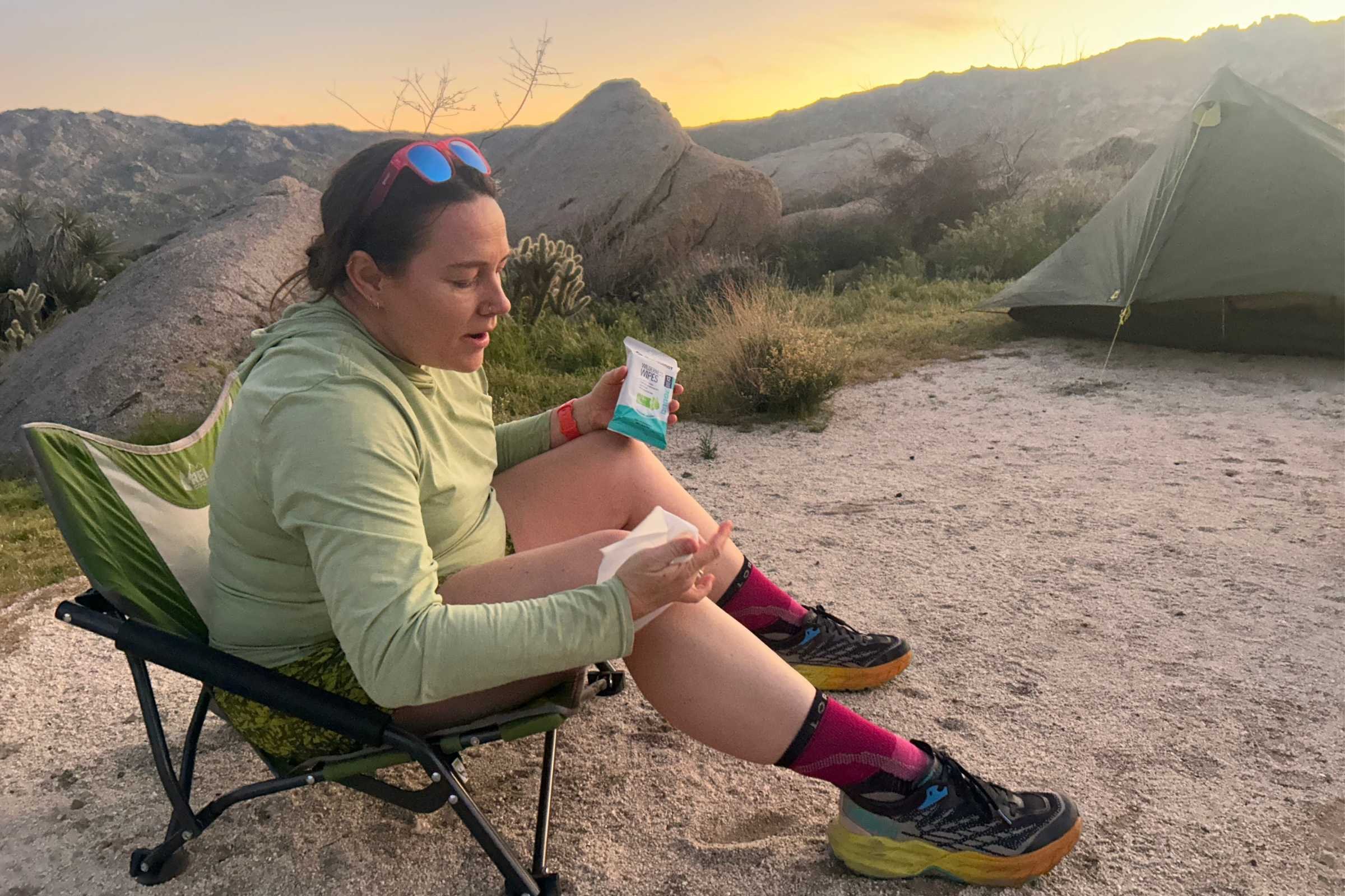   Tester sitting in a camp chair using Sea to Summit Wilderness Wipes  