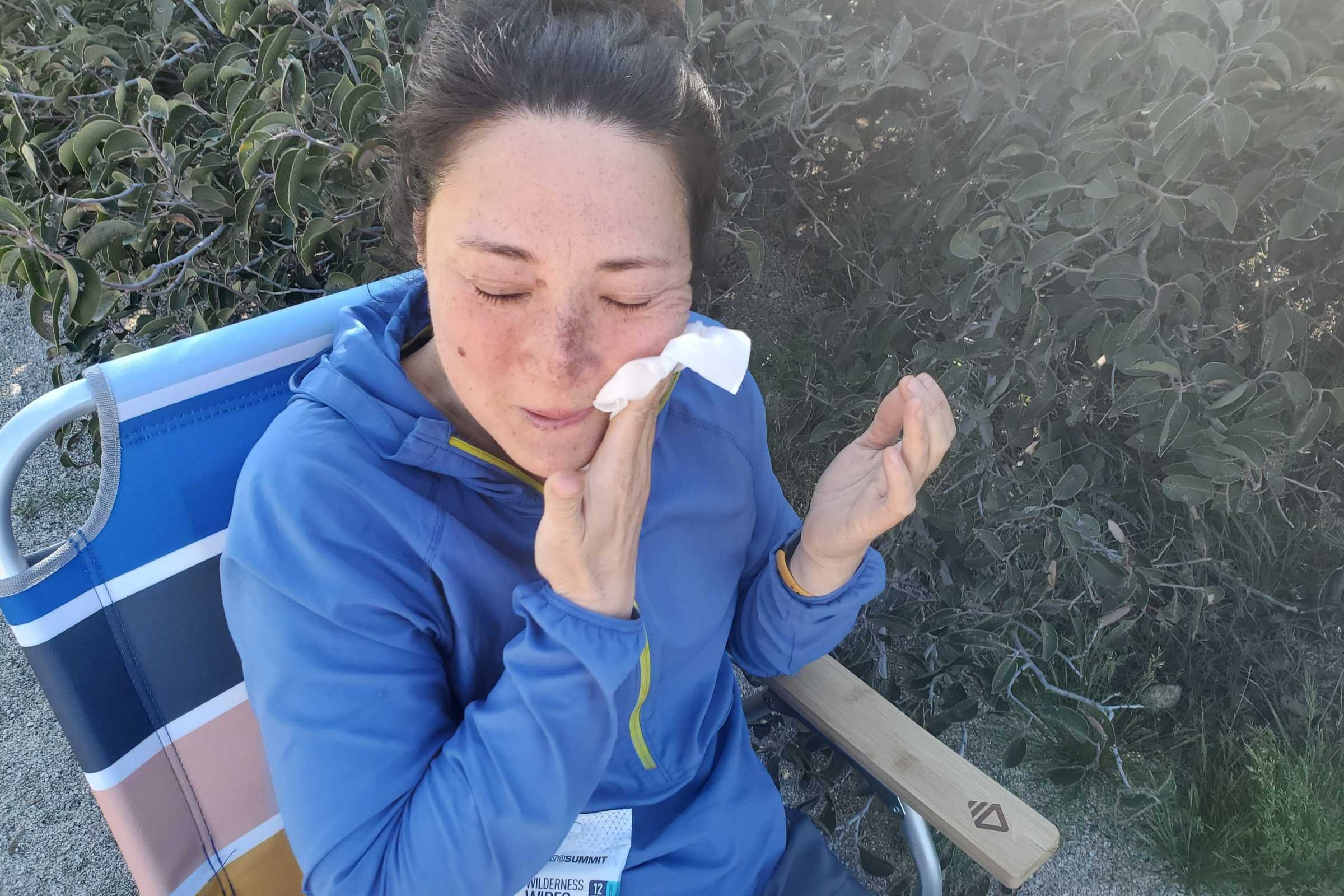   Tester outside using a Sea to Summit Wilderness Wipes to clean their face  
