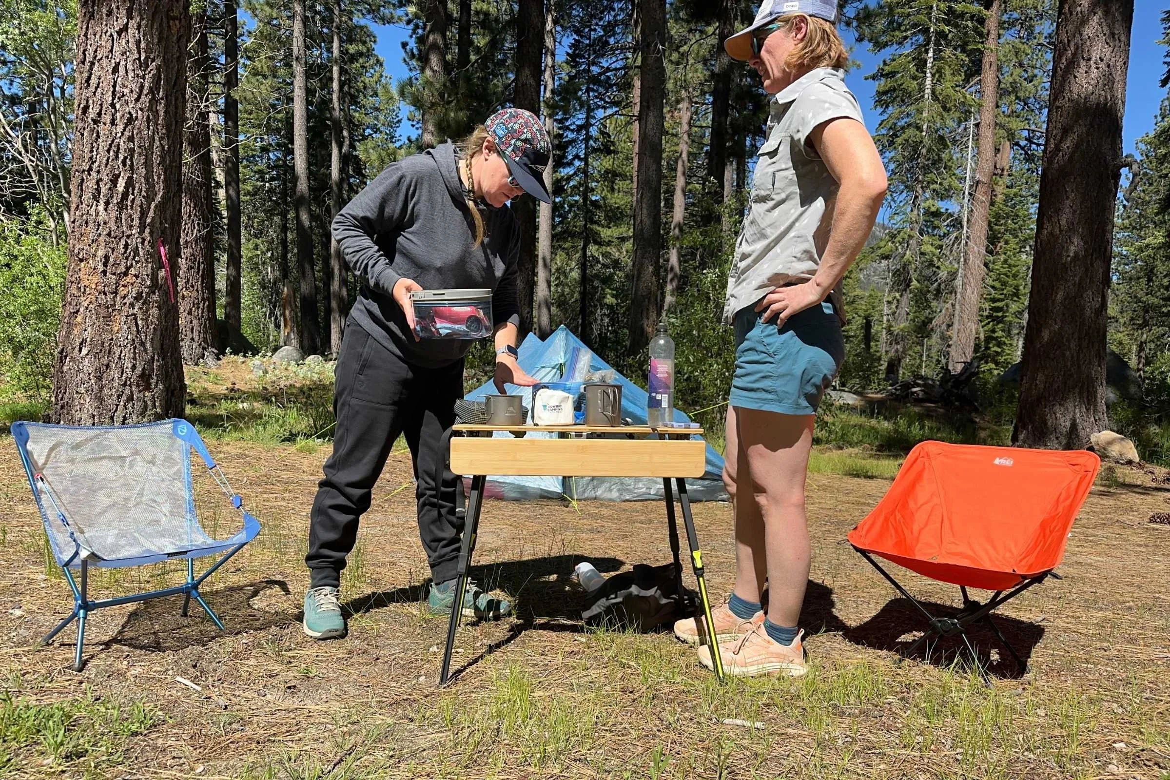  Two campers preparing coffee on the Zempire Kitpac Pro camping table.  