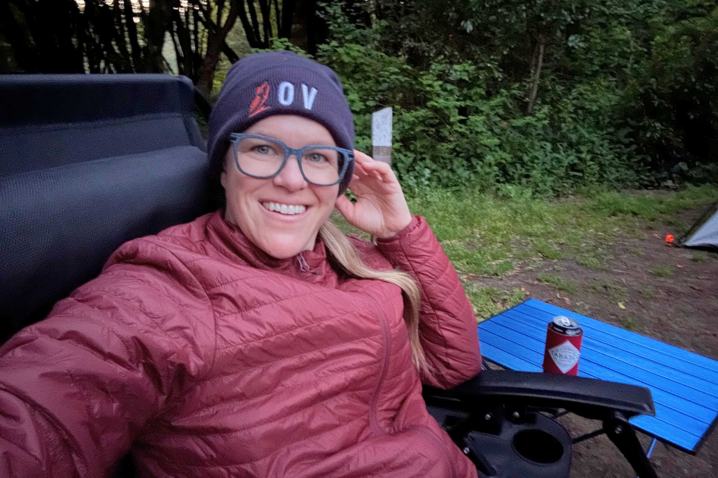   Camper relaxing beside Rock Cloud Portable Camping Table at a campsite  