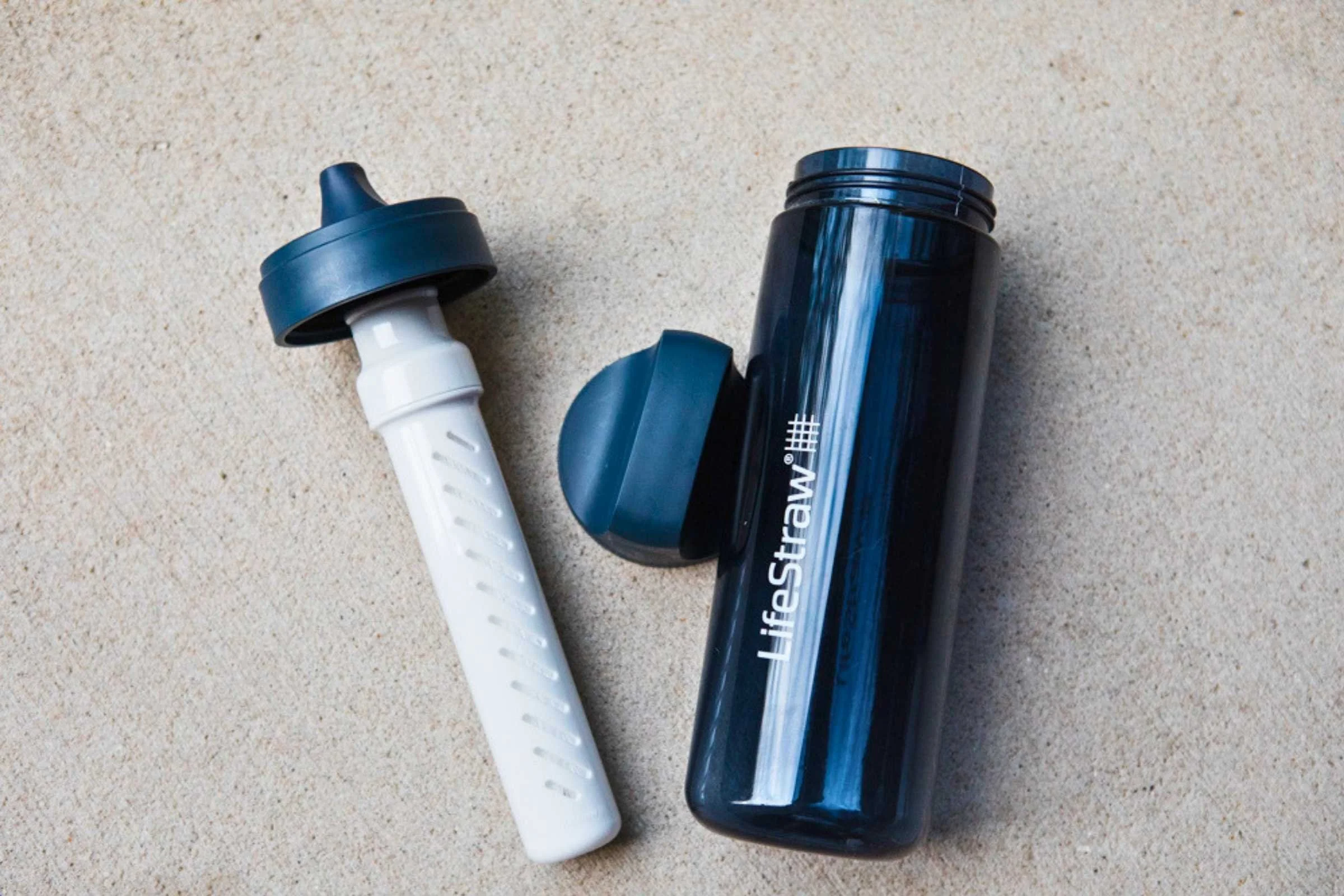   A filter water bottle being filled at a tap, with the filter element visible through the transparent body.   Photo courtesy Karthika Gupta  