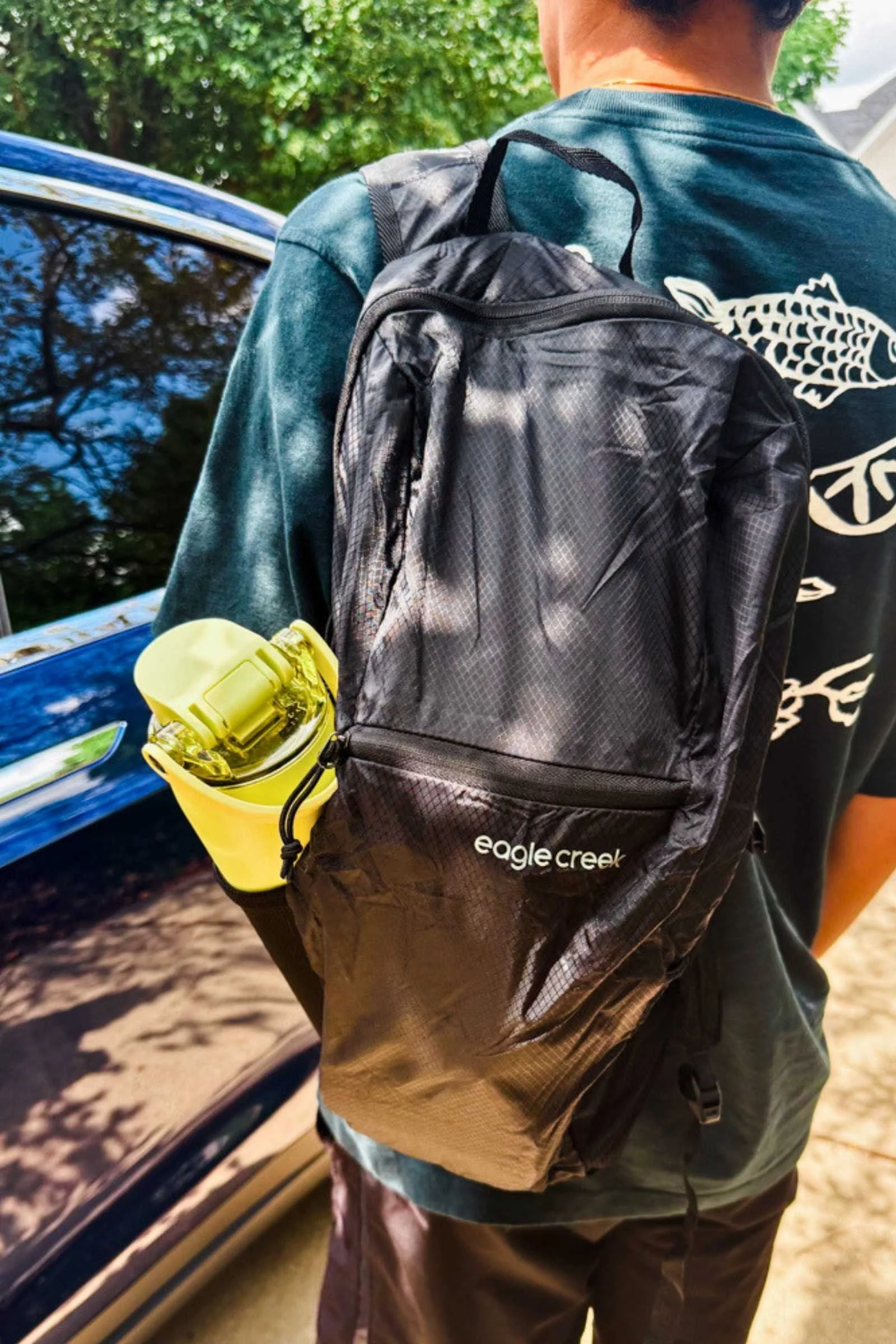   The Eagle Creek Packable Backpack fits comfortably over the shoulder, with a water bottle tucked into its stretch side pocket.  