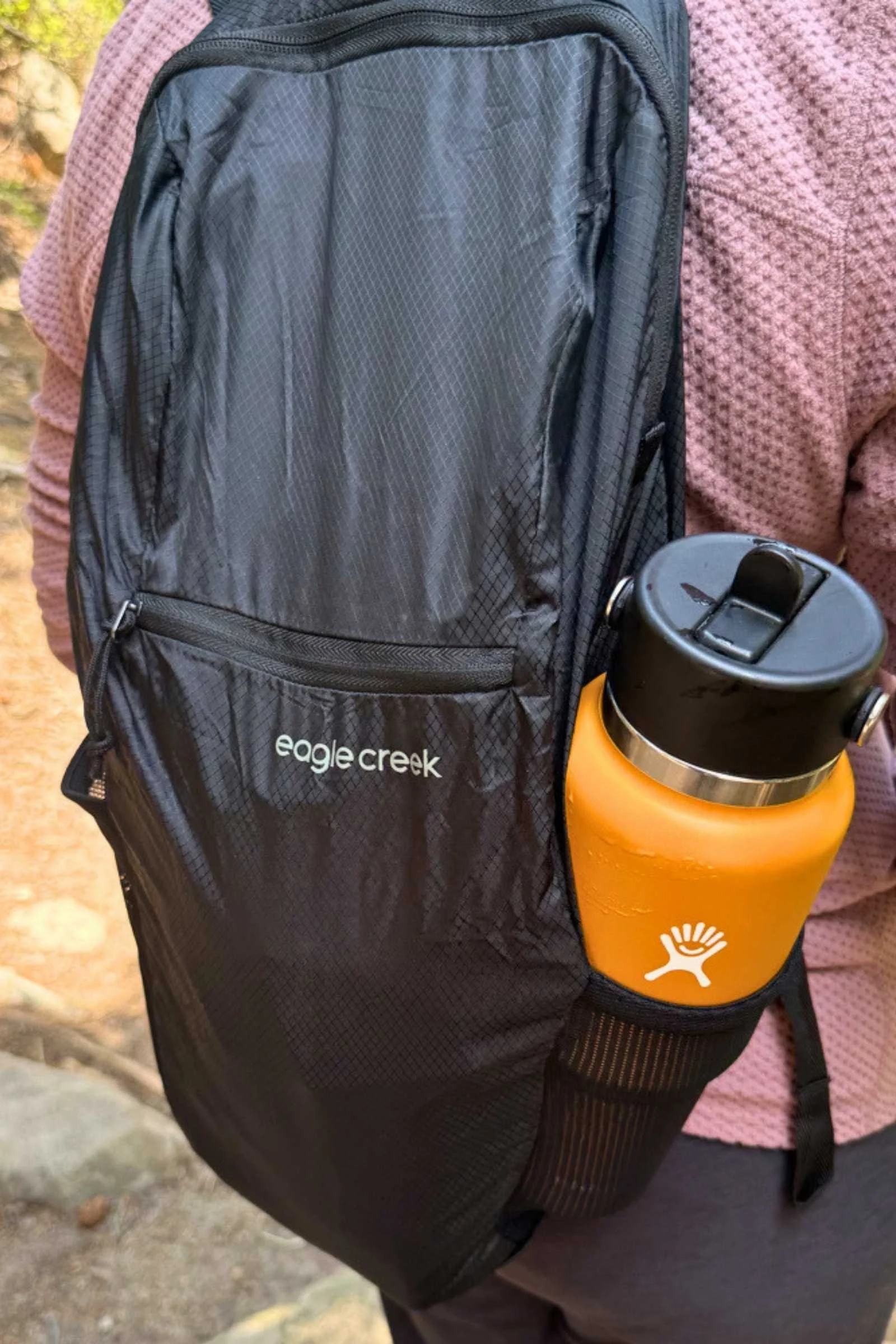   The Eagle Creek Packable Backpack holds two water bottles in its stretch side pockets, showing how much it can carry despite its lightweight design.  