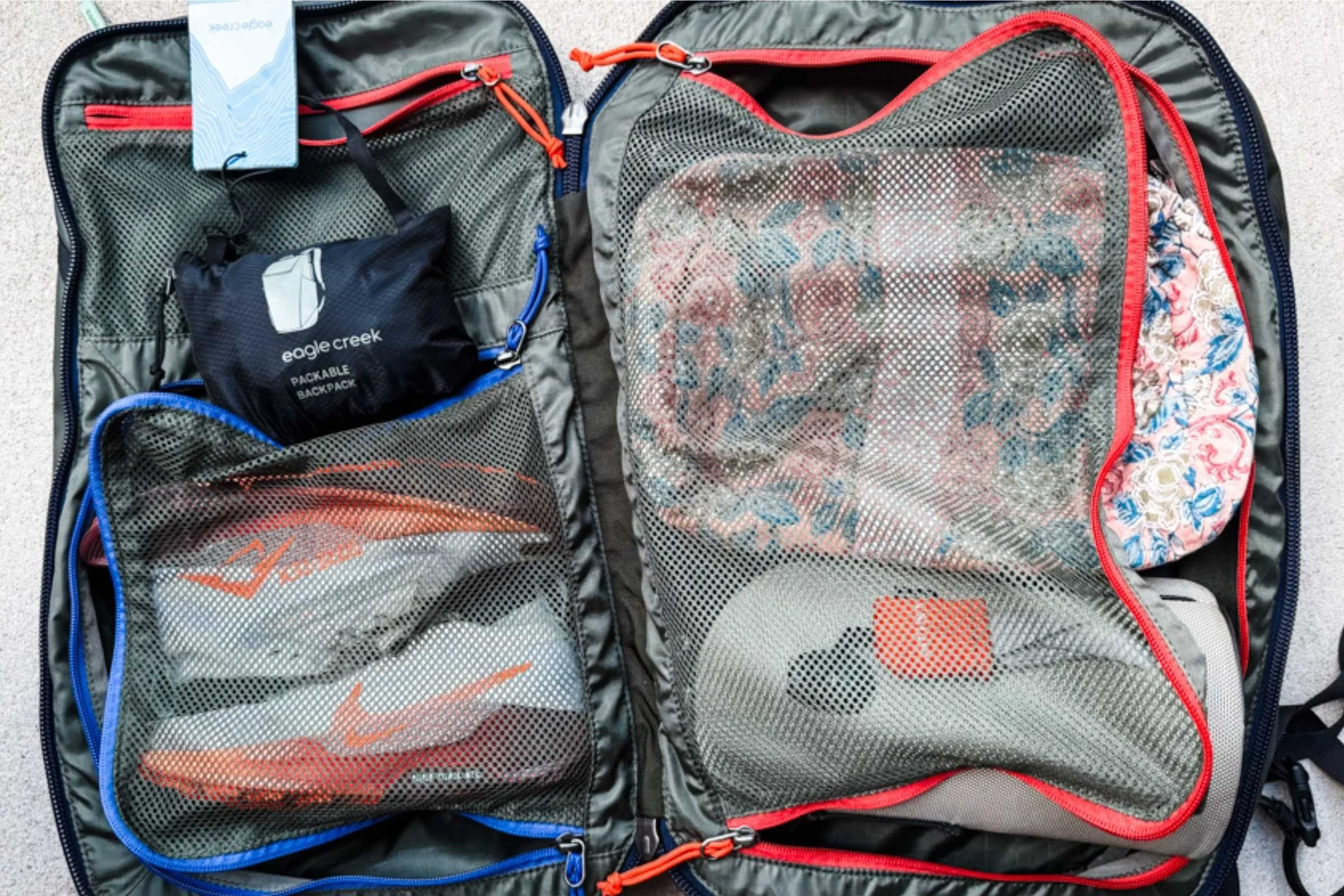   The Arc’teryx Heliad 15 packed with clothing and essentials, showing its interior compartments and organization.  
