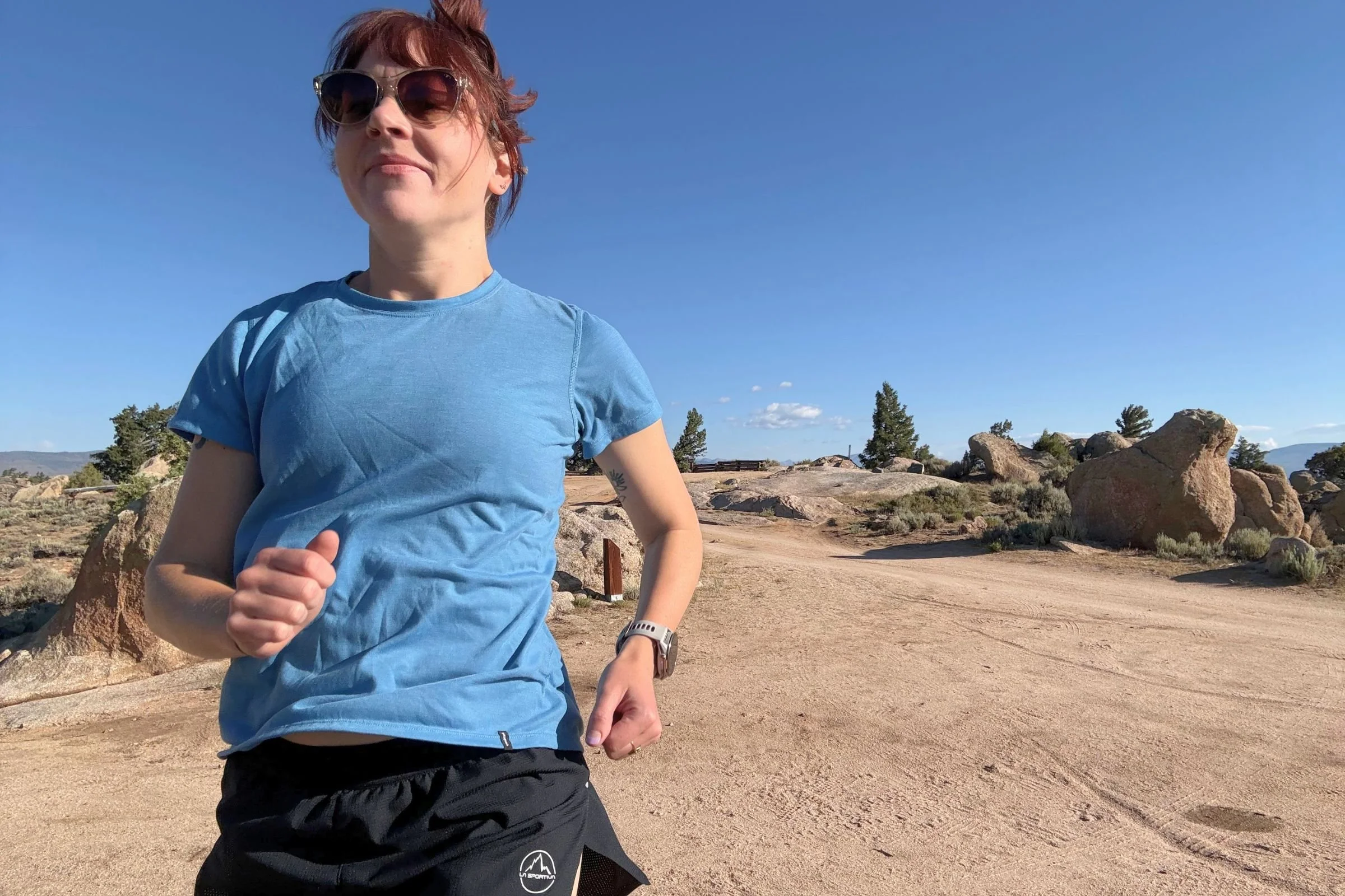   A runner wearing the Patagonia Capilene Cool Trail shirt on a sunny trail.  